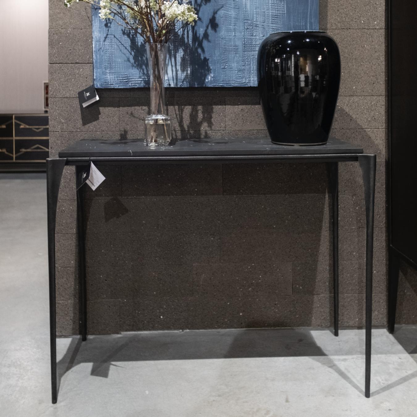 Metal console with a very delicate and fine design. Its base is made of iron which together with the black marble top manage to give a very elegant look.
