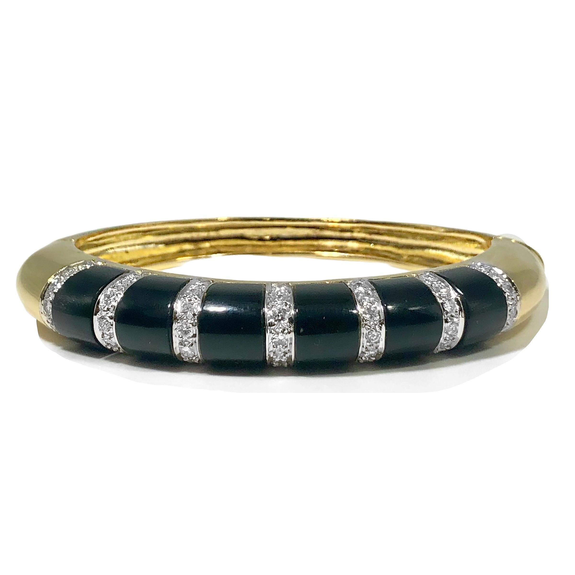 This iconic hinged bangle bracelet fabricated from 18K yellow gold, black onyx and diamonds, screams 1970's design. The bracelet was crafted with the finest quality materials and workmanship. Total approximate diamond weight is 1.25ct of overall G/H