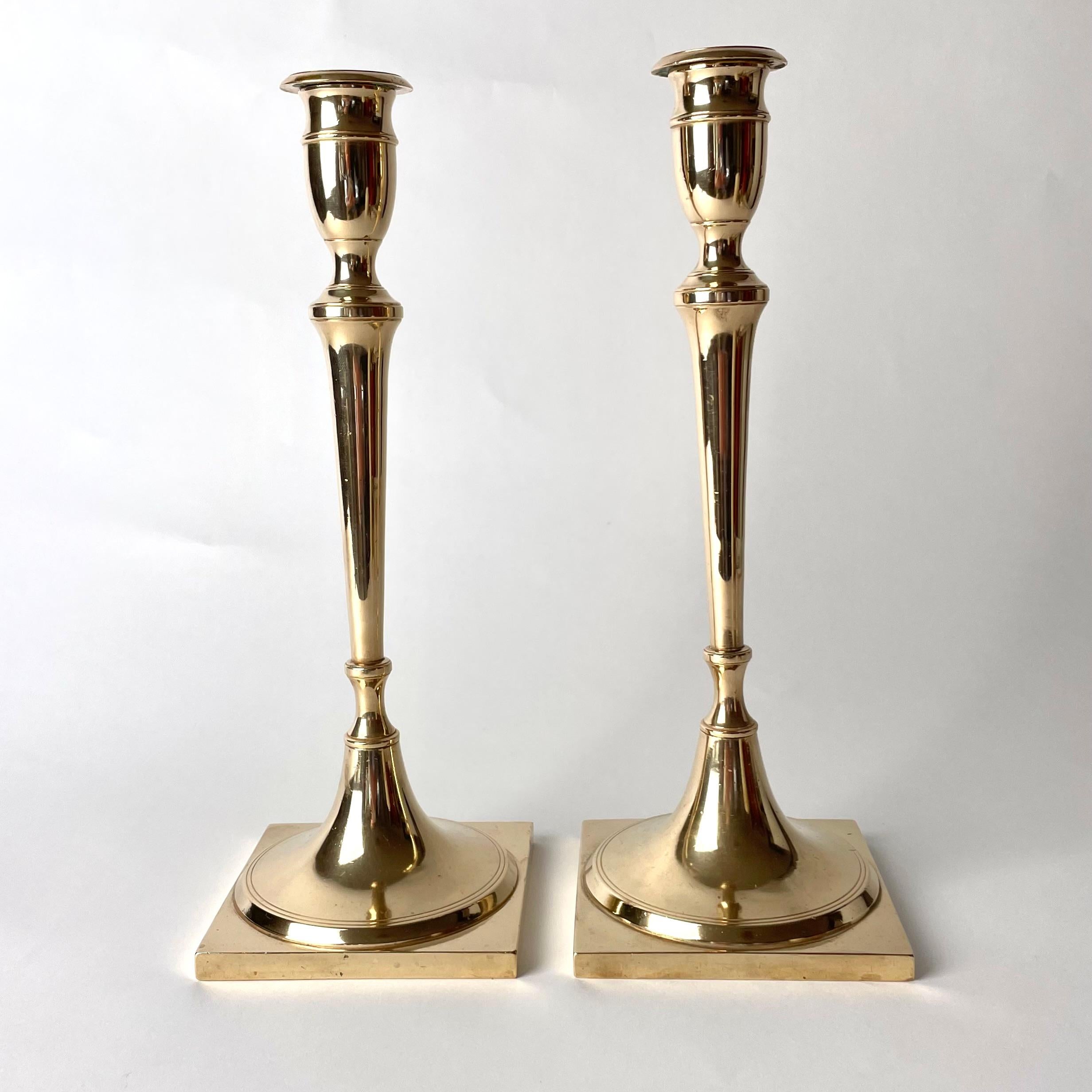 Elegant and large pair of Brass Candlesticks. Swedish Karl Johan from the 1820s. (Swedish Empire). Simple and beautiful model with a square base and only two stripes as decoration.

Wear consistent with age and use 