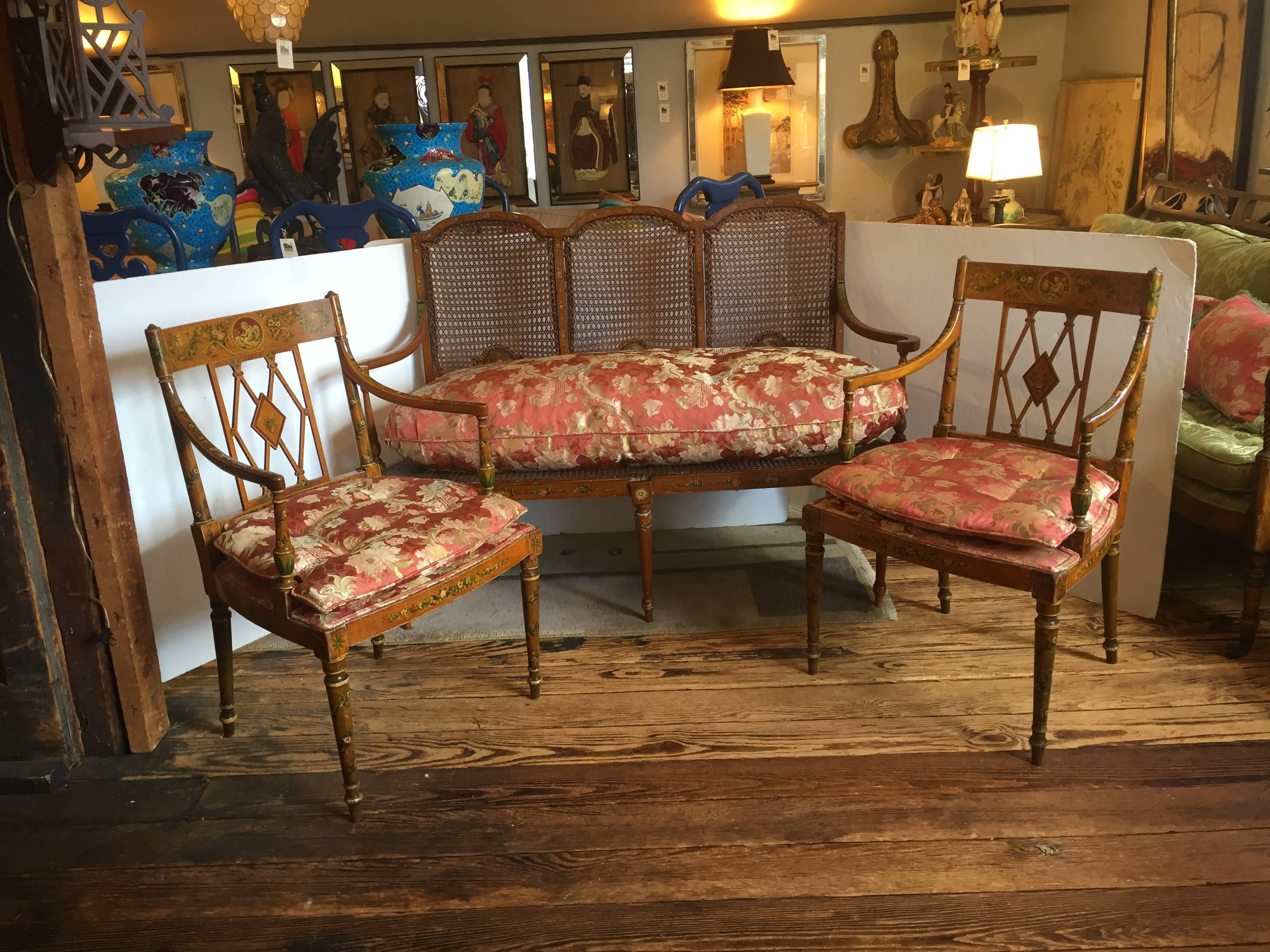 Heartbreakingly beautiful Italian antique salon set including matching loveseat and pair of arm chairs, with hand-painted details of portraits, putti, leaves and flowers, as well as caned areas and upholstery in very elegant Scalamandre silk. Truly