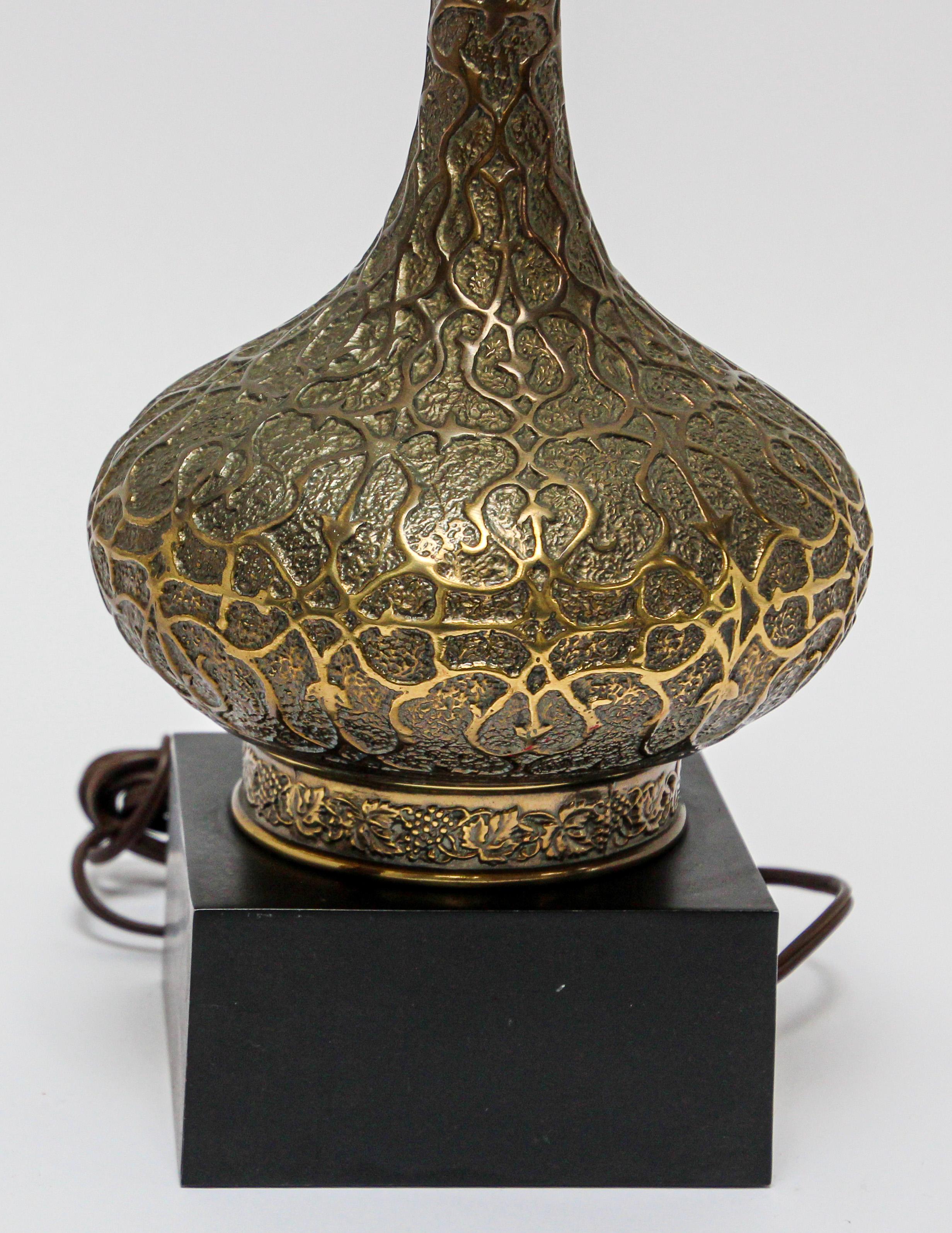 Elegant tall Moorish brass table lamp.
Intricately designed brass onion form with long neck on a square wooden base.
Cast brass with foliages Moorish Arabesque style designs.
Base is: 5