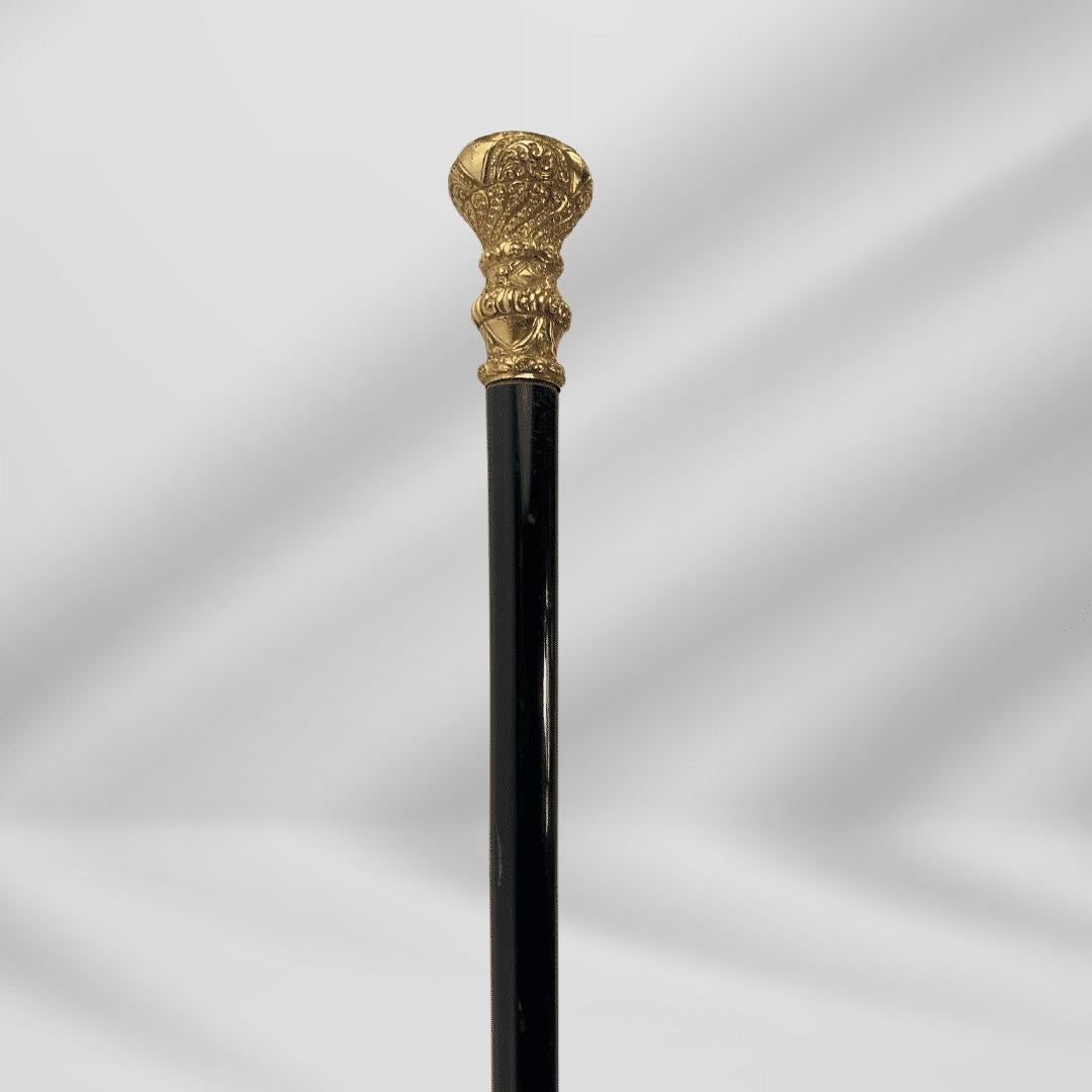 Elegant Antique Carved Gold Plate Knob Handle Walking Stick Cane Black

This beautiful and highly detailed piece has a large and ornate handle set atop a black wooden shaft. The Collar has multiple bands of decoration that not only make the design