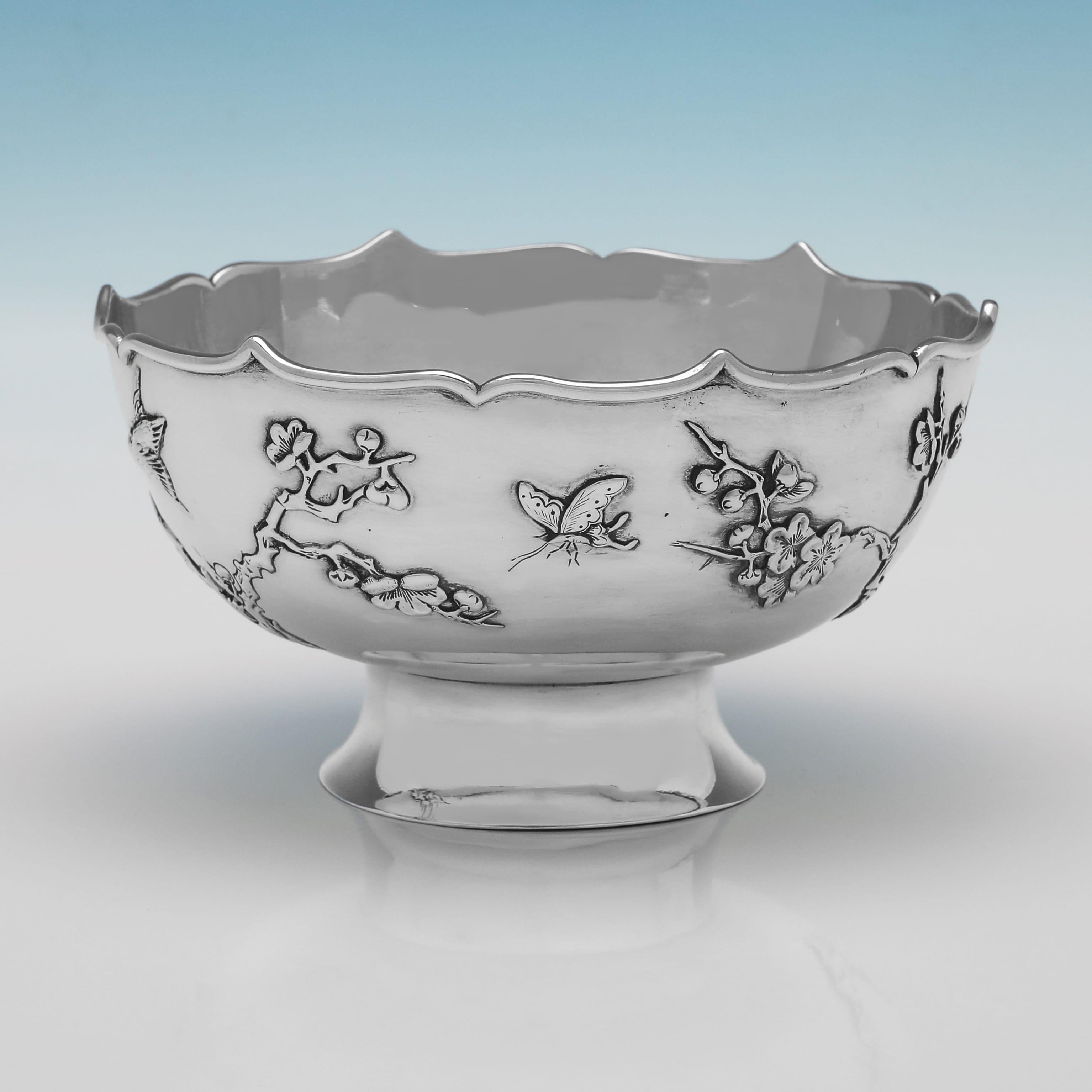 Made circa 1910 by Sing Fat, this elegant antique Chinese Export Silver bowl is of a circular form with a scalloped rim and stands on a pedestal foot. The body is decorated with an applied decoration of a bird perched on a cherry blossom branch and