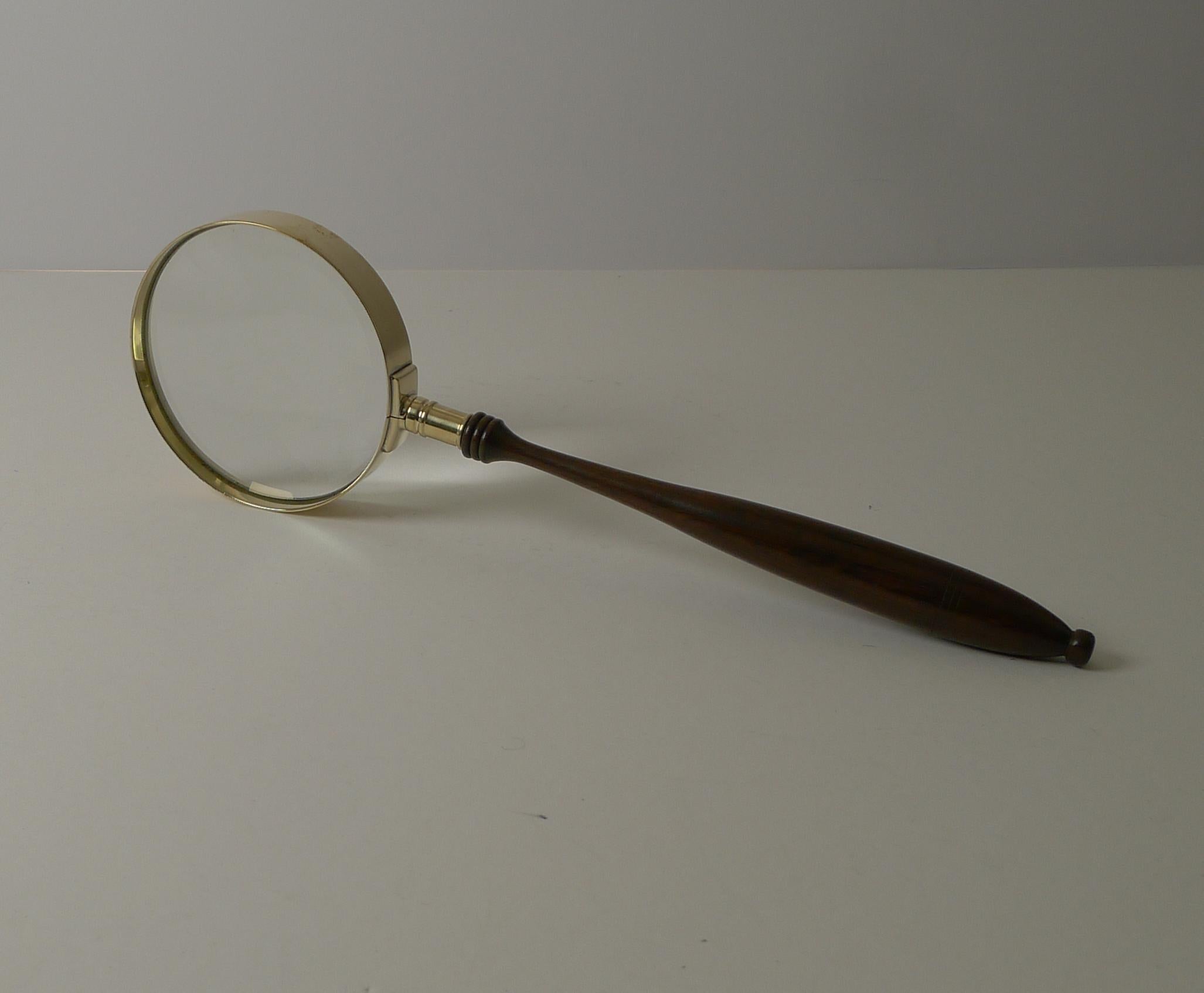 A very handsome and unusual late Victorian / early Edwardian magnifying glass with it's extremely long turned wooden handle.

The brass frame has been professionally polished, restoring it to it's former glory. The glass has a good magnification
