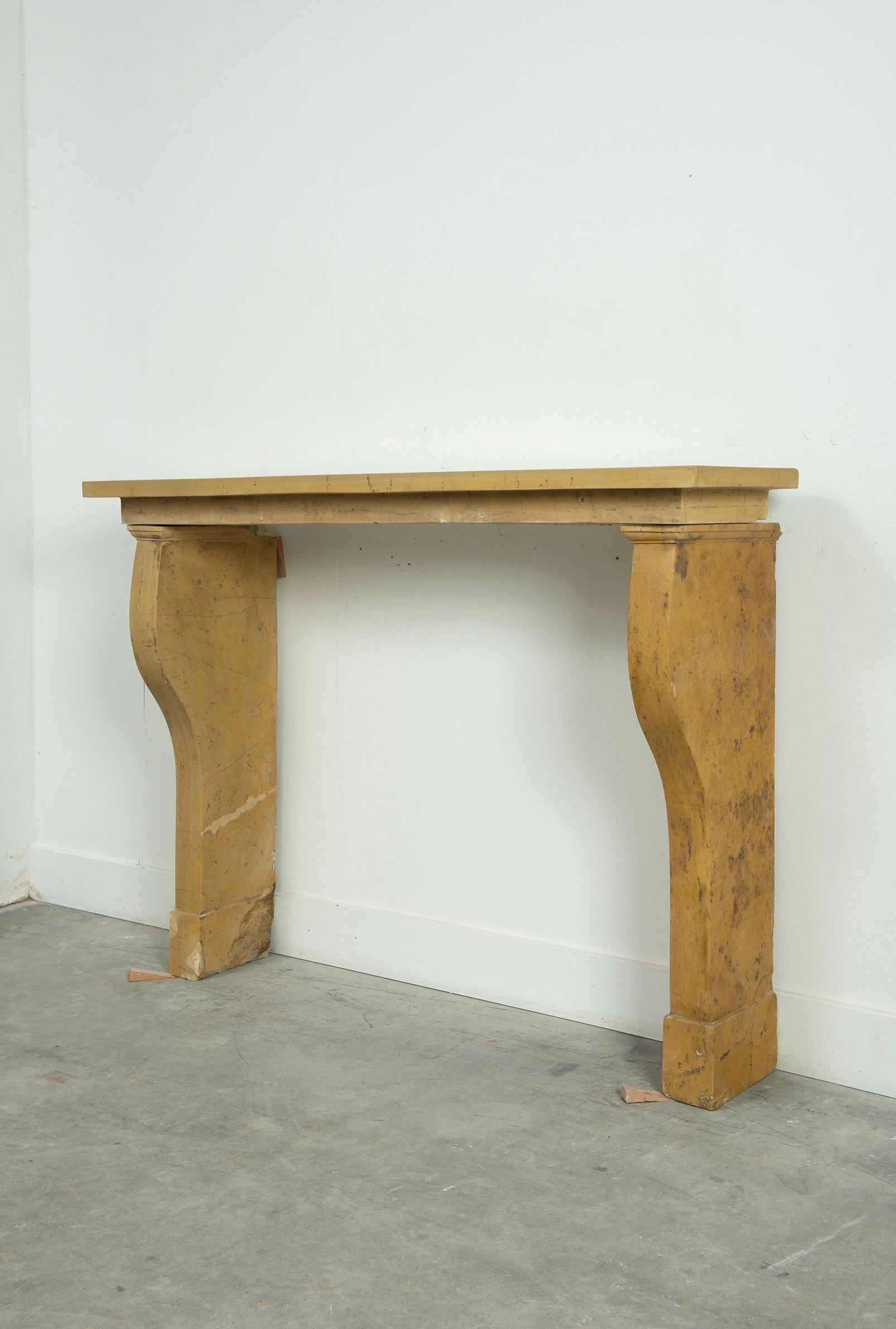 Antique limestone fireplace mantel from France. 
Its clean lines and graceful proportions make it an ideal choice for those who appreciate timeless design and superior craftsmanship. The warm, honey-toned limestone exudes a natural charm that