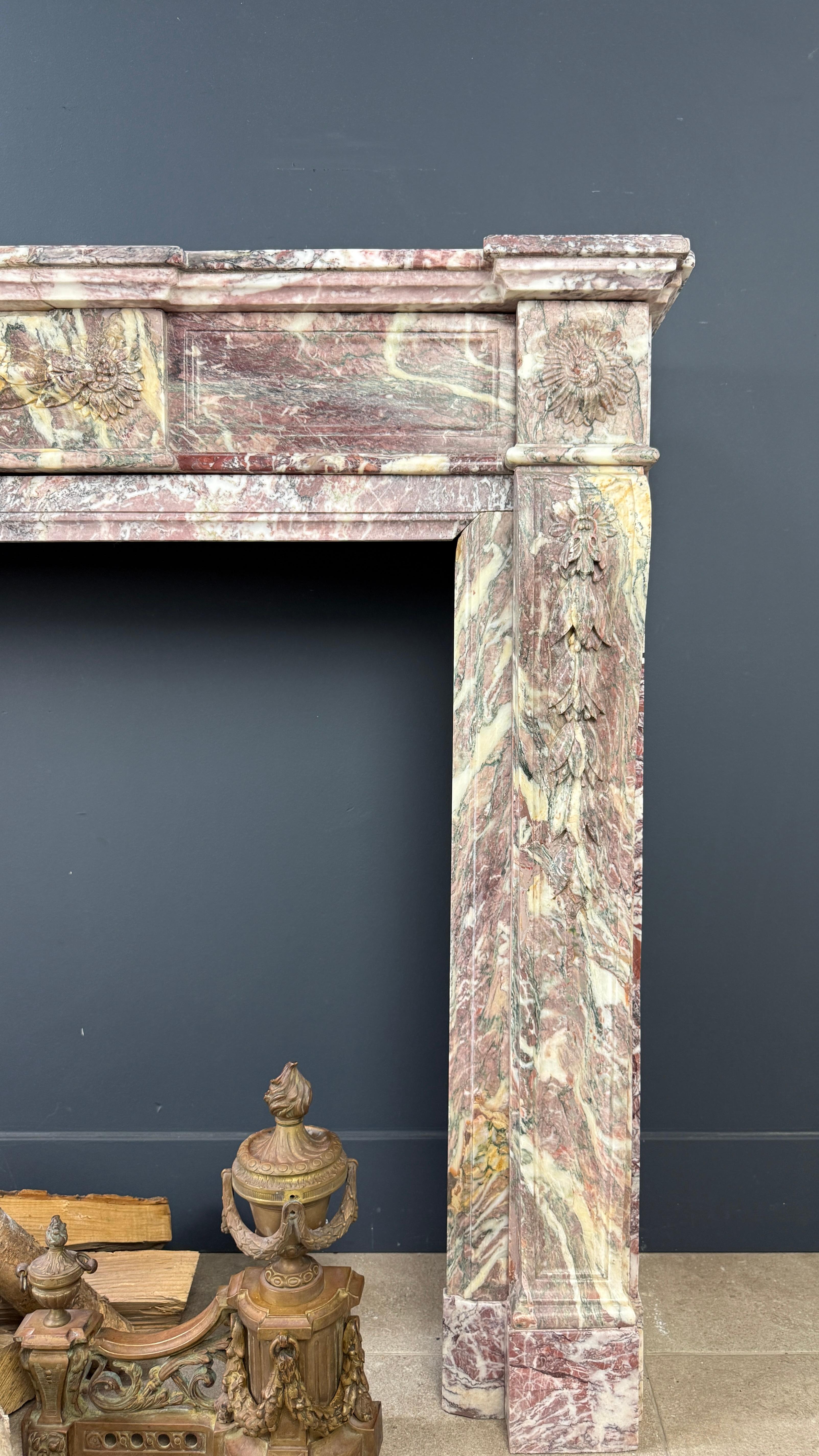 Esta antigua repisa de chimenea Luis XVI es una pieza excepcional, elaborada con el raro e históricamente significativo mármol Fleur de Pêcher. Esta vibrante piedra, con sus matices de rosa, violeta y rojo, se utilizó mucho en el siglo XIX para