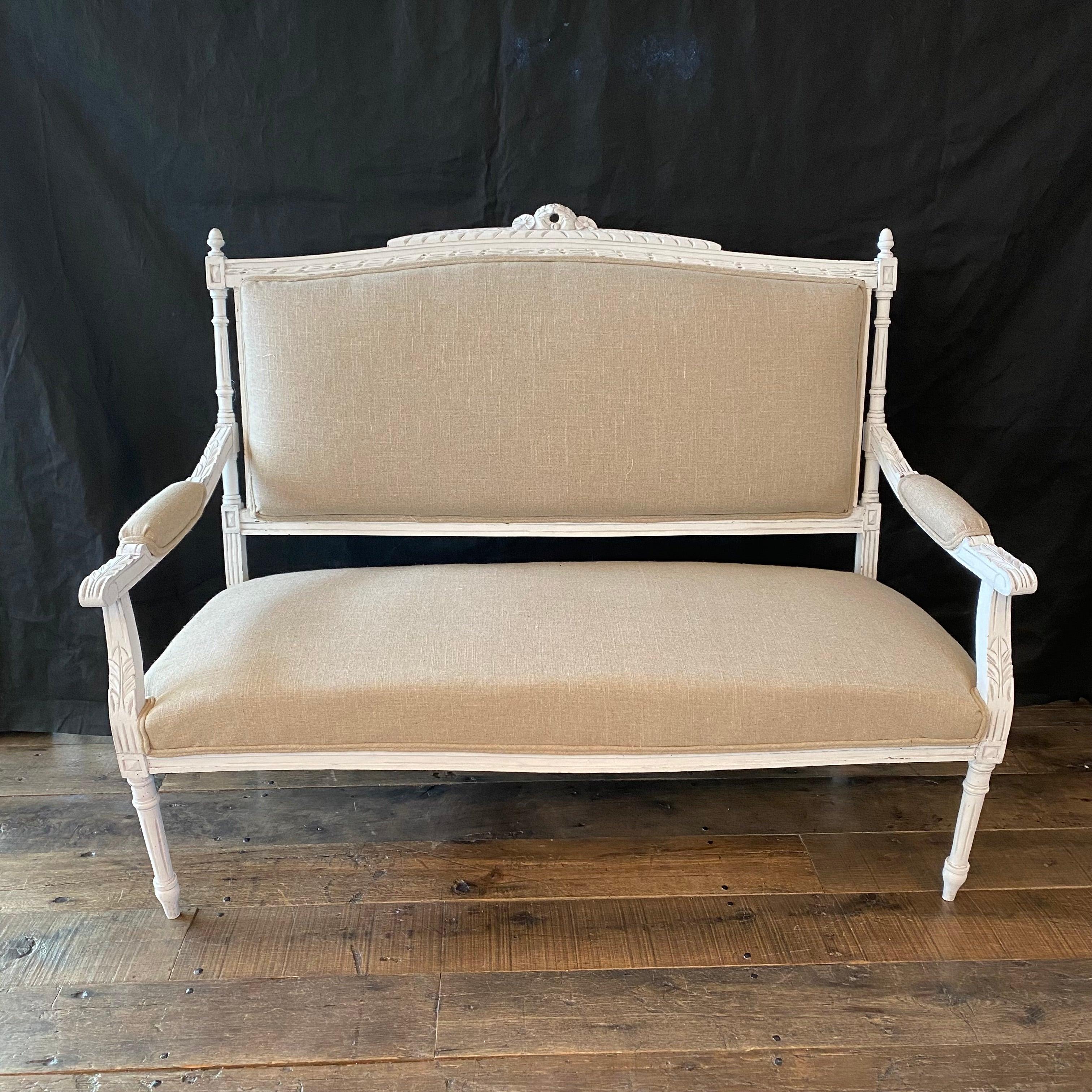 Charming 19th century Louis XVI ivory and beige loveseat, settee or sofa. Beautifully carved frame and new neutral upholstery. #3931

 H seat 16” H arm 23.5”.