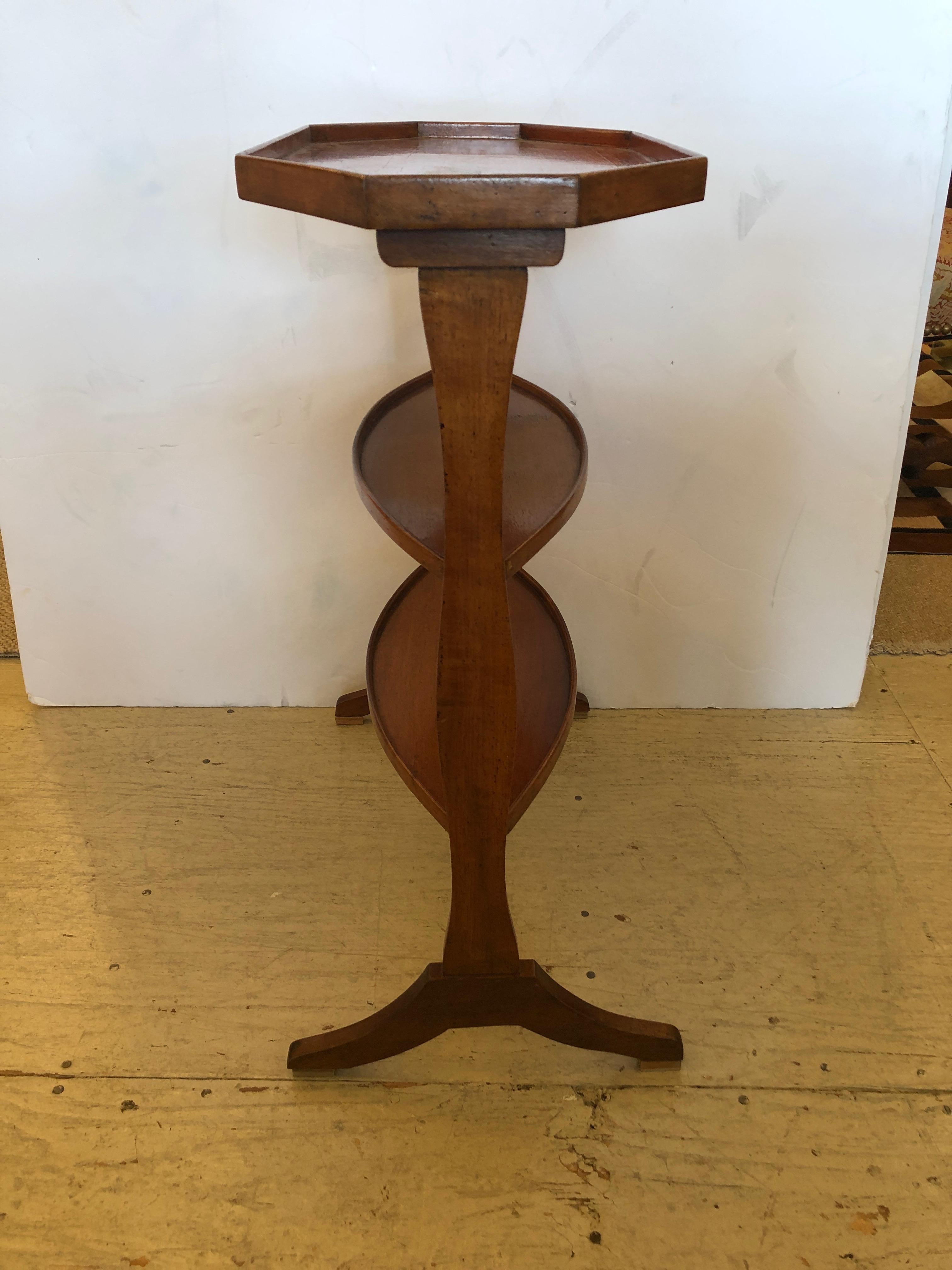 Superb antique Italian fruitwood side table having 3 tiers including an elongated octagonal top, two oval shelves below and a very elegant refined silouette.