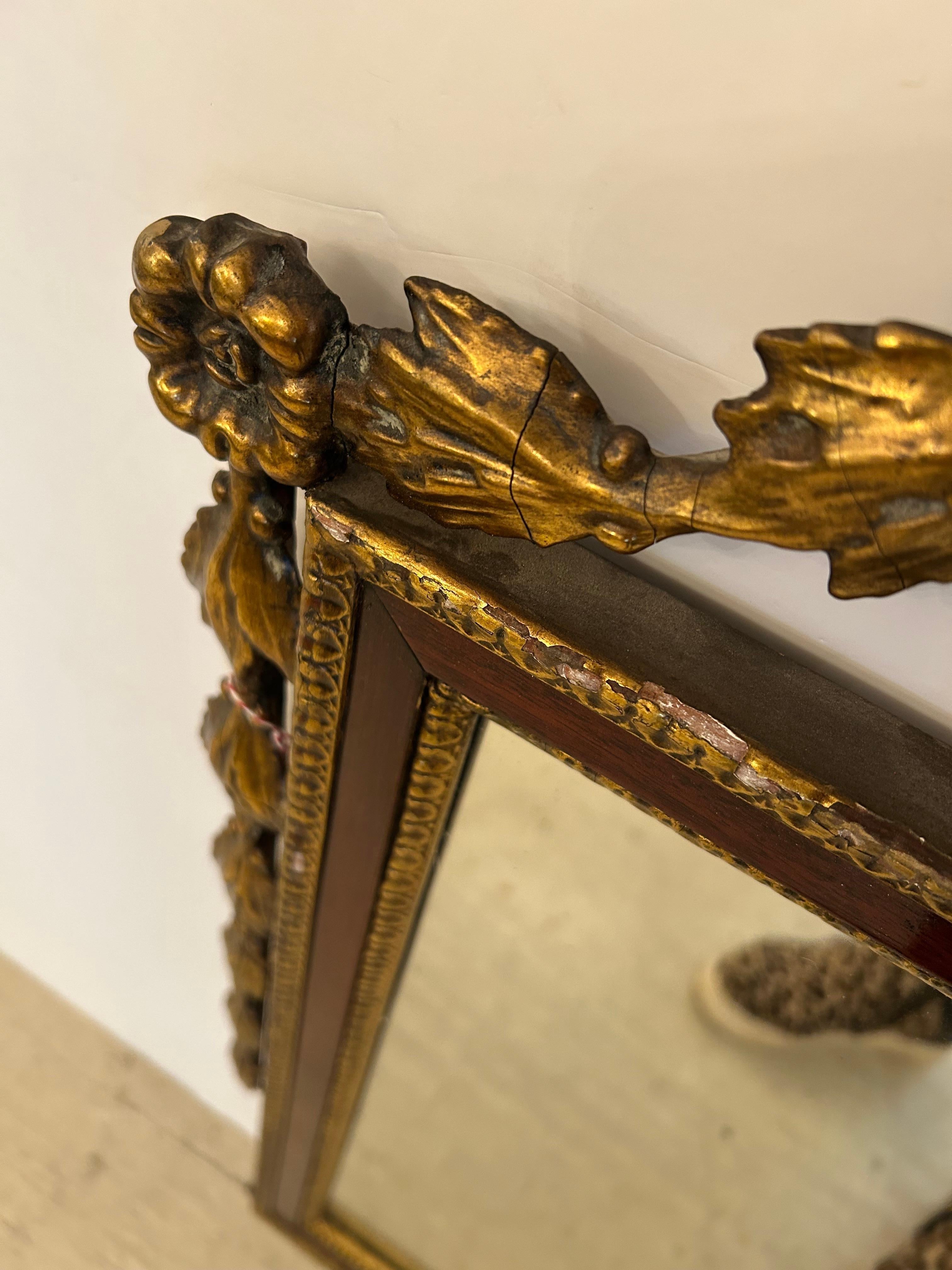 Elegant antique mahogany and giltwood Regency mirror having lovely swags along each side and flower basket adornment at the top.