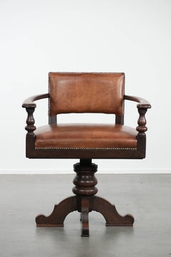 Elegant antique sheepskin leather desk chair with a heavy wooden frame