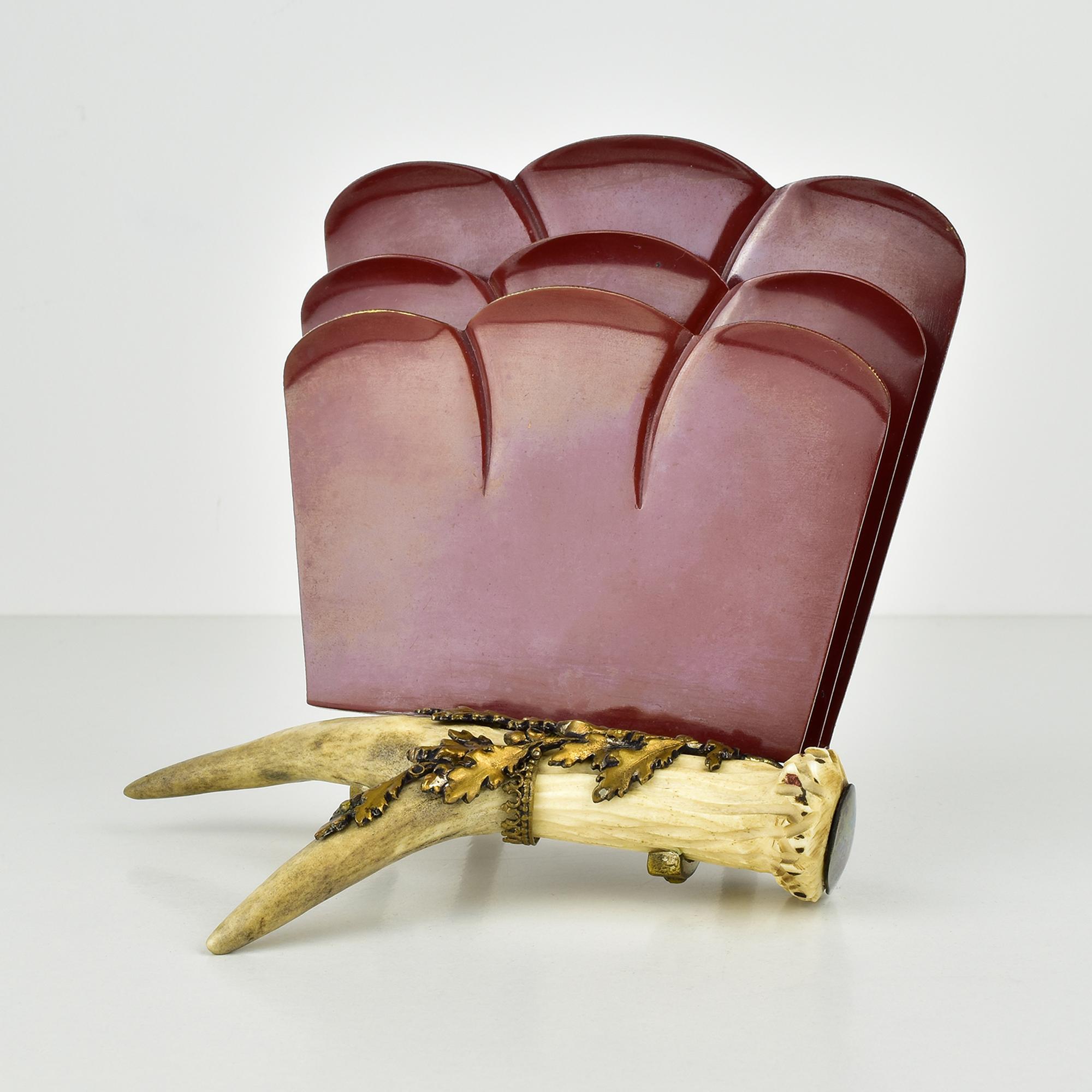 This letter holder features a unique design that elegantly blends materials and forms. The base is crafted from a natural antler, imparting an organic and rustic charm.

The main body consists of several curved panels that rise gracefully from the