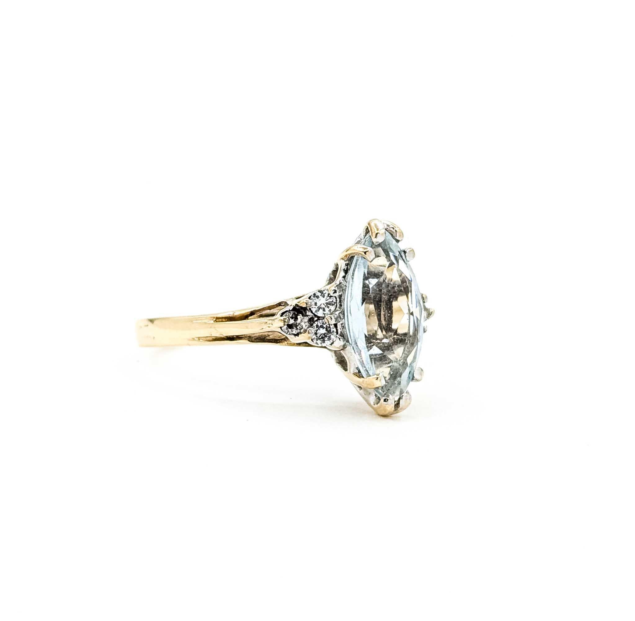 Questo elegante anello è realizzato in oro giallo 10k e presenta al centro un'acquamarina taglio marquise incastonata. L'acquamarina mostra una morbida tonalità blu acqua, splendidamente accentuata da diamanti rotondi per un totale di 0,06 carati,