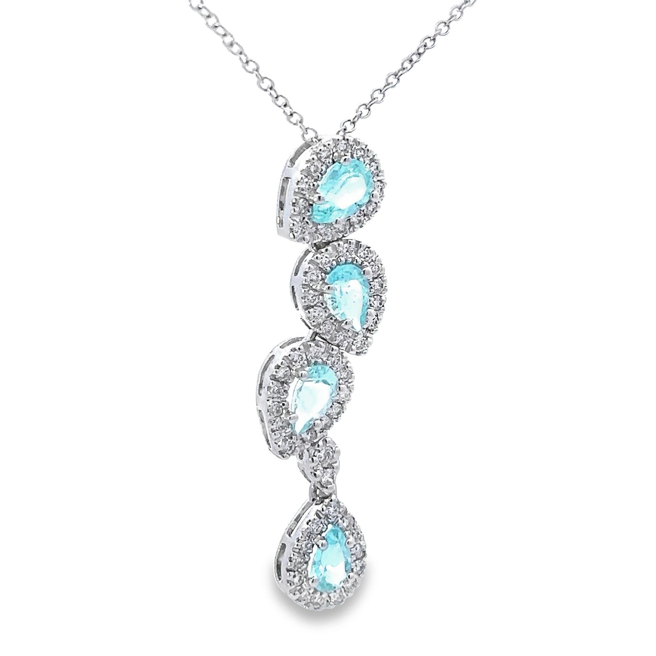 Ce collier pendentif exquis présente une cascade de pierres précieuses aigue-marines, chacune entourée d'un halo étincelant de diamants sertis en pavé. La teinte bleue sereine des pierres rappelle les mers tranquilles, faisant de cette pièce un