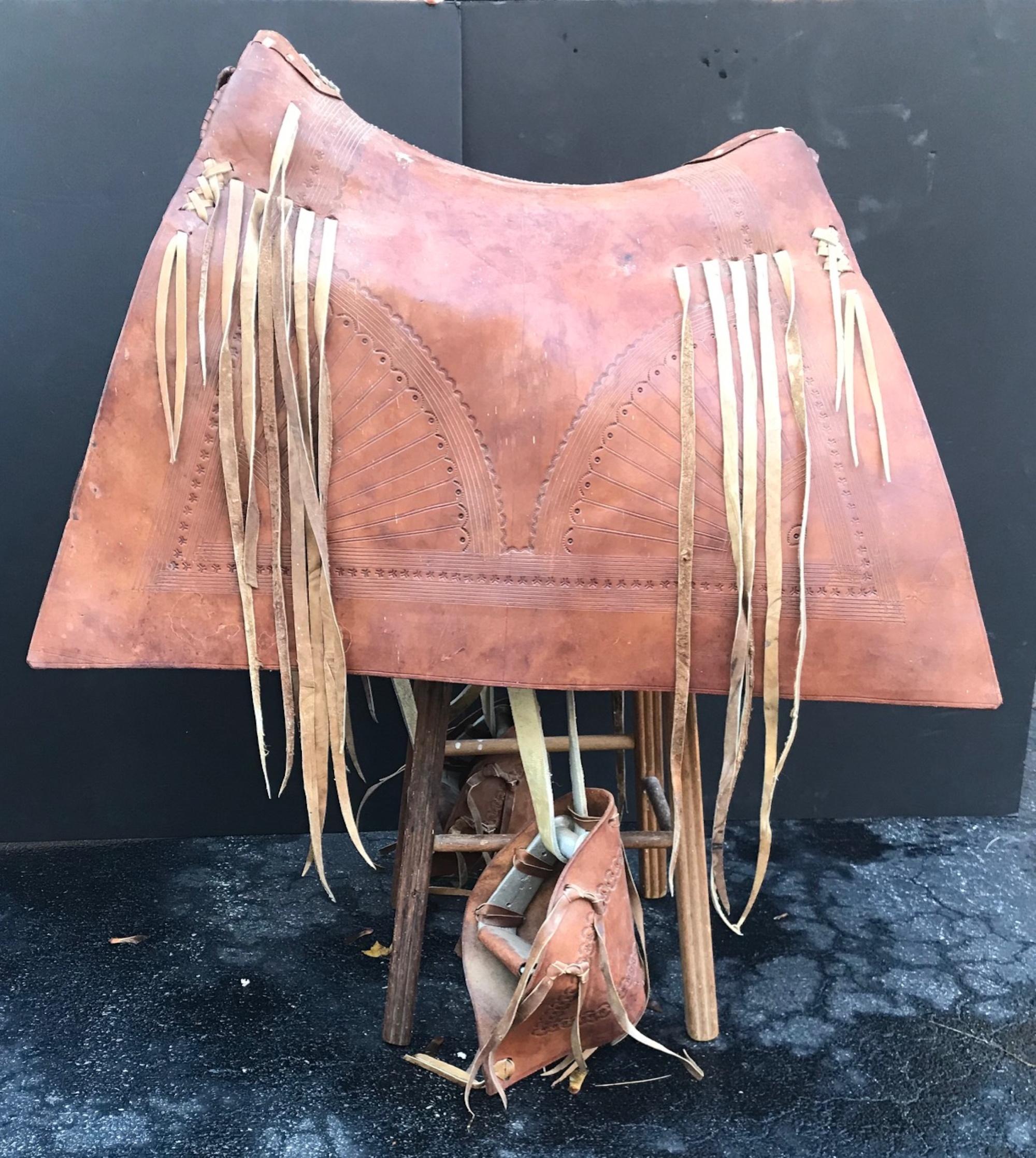 Stately and elegant Argentine gaucho saddle with tapaderos hooded stirrups, used by the famed South American horsemen of the pampas. This decoratively tooled saddle, in its almost new condition, is undoubtedly crafted for presentational use. It is