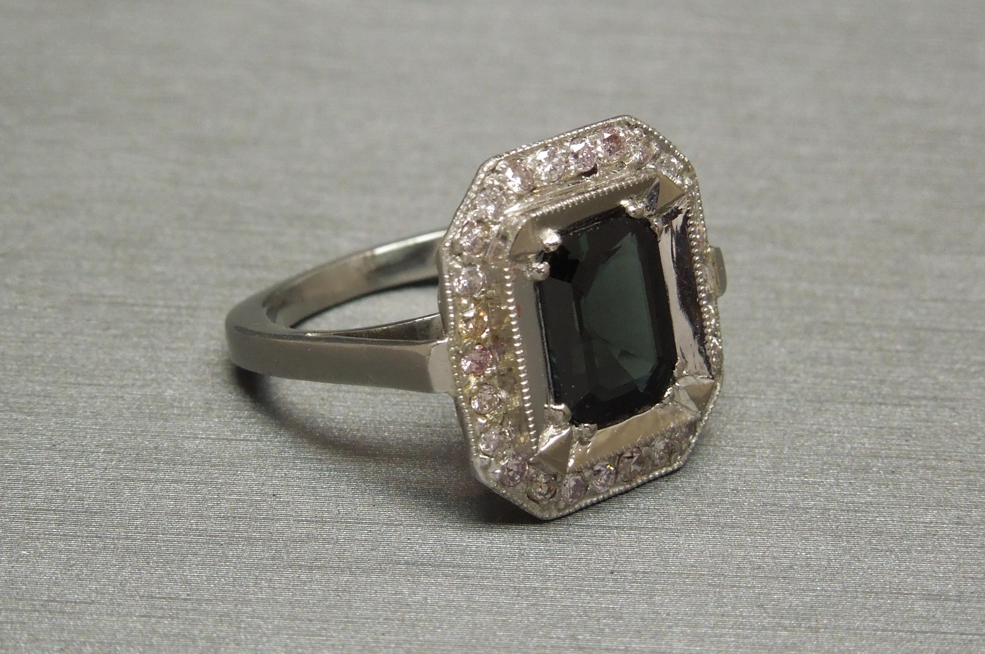 This period Art Deco ring in a combination of White Gold & Platinum features an Elegant central 2.85 carat Emerald cut Natural Blue Sapphire measuring 9.1mm x 7.2mm bordered by a total of 0.65 carats of Natural Light Pink Round Brilliant cuts