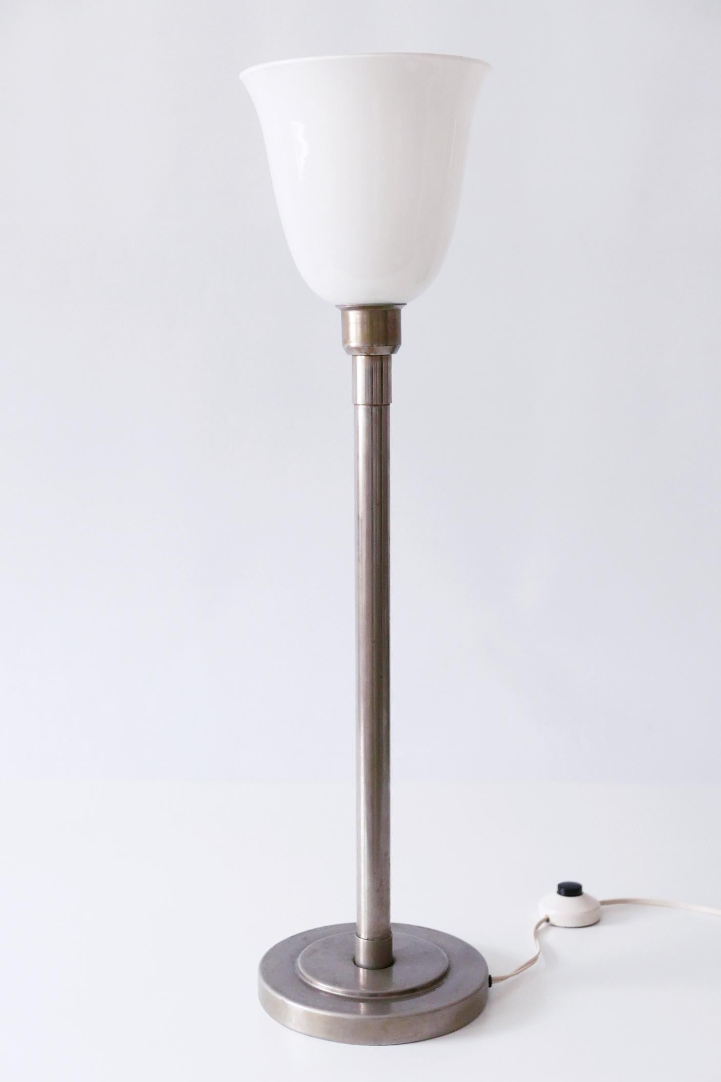 Elegant Art Deco / Bauhaus floor or table lamp. Designed and manufactured probably in 1930s, Italy.

Executed in nickel-plated brass and opaline glass, the lamp needs 1 x E27 / E 26 Edison screw fit bulb, is wired, and in working condition. It runs