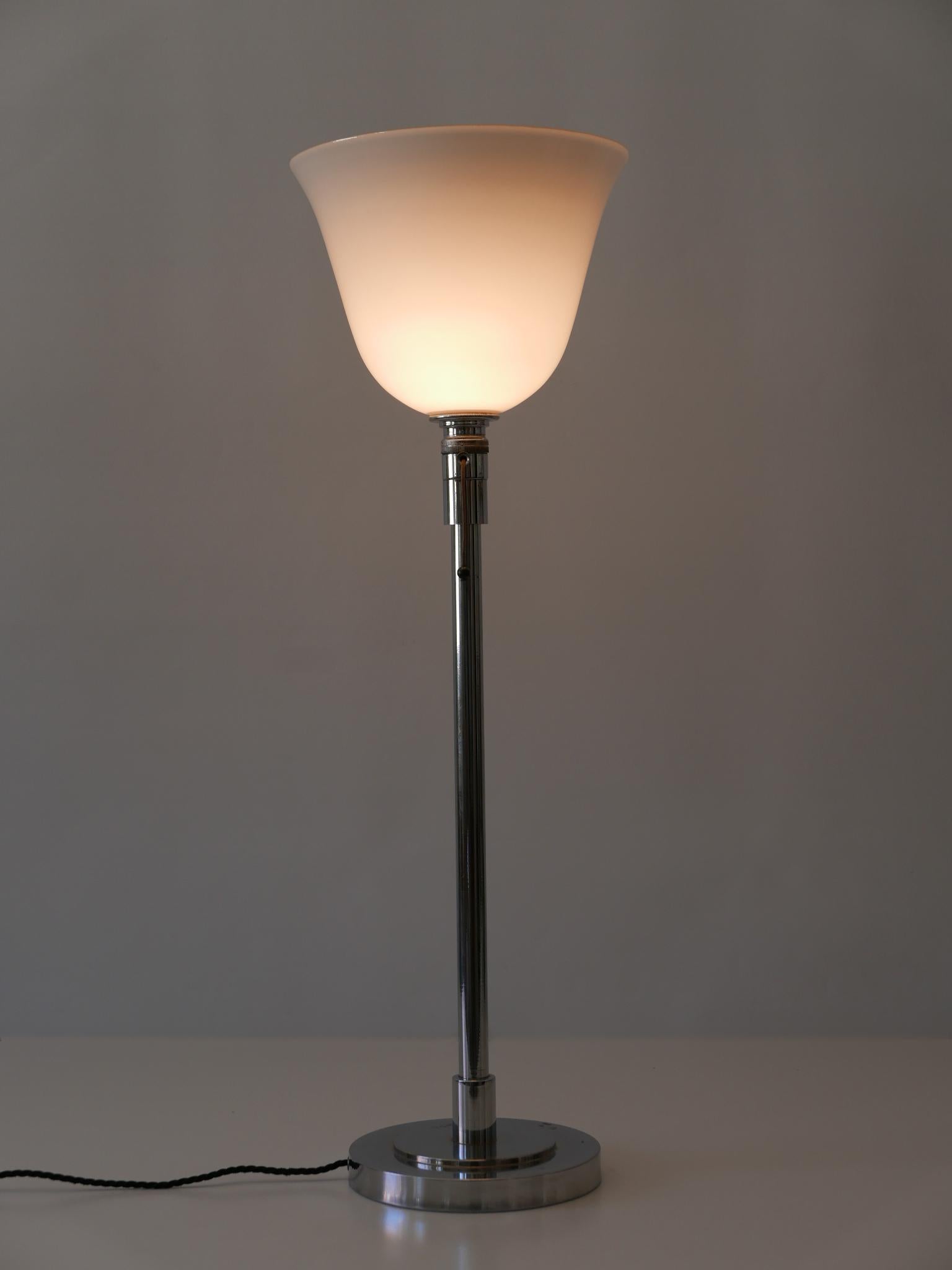 Elegant Art Deco / Bauhaus floor or table lamp. Designed and manufactured by Mazda, 1930s, Paris, France.

Executed in nickel-plated brass and opaline glass, the lamp needs 1 x E27 / E 26 Edison screw fit bulb, is wired, and in working condition.