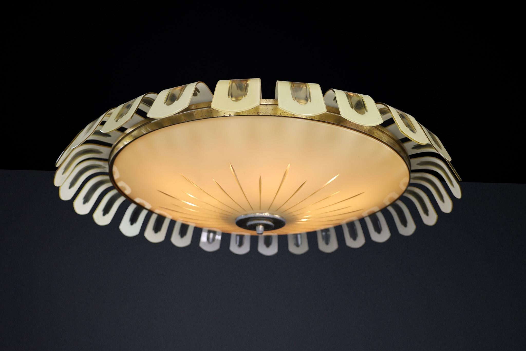 Elegant Art Deco Brass and Green Opaline Glass Chandelier, Germany 1930s

This exceptional chandelier is a prime example of German Art Deco design from the 1930s. It features a circular brass frame adorned with stylized, U-shaped decorative elements