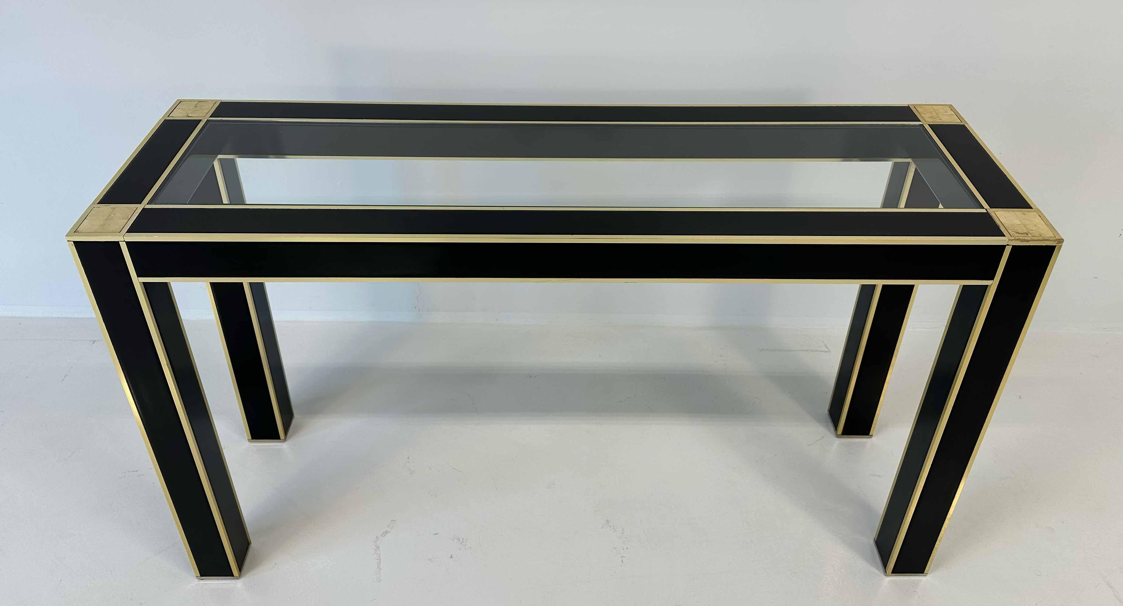 Elegant and refined, this console attributed to Willy Rizzo is a fine example of Art Deco design, characterized by clean geometric lines and luxurious materials. The structure is entirely finished in glossy black lacquer, which adds depth and a