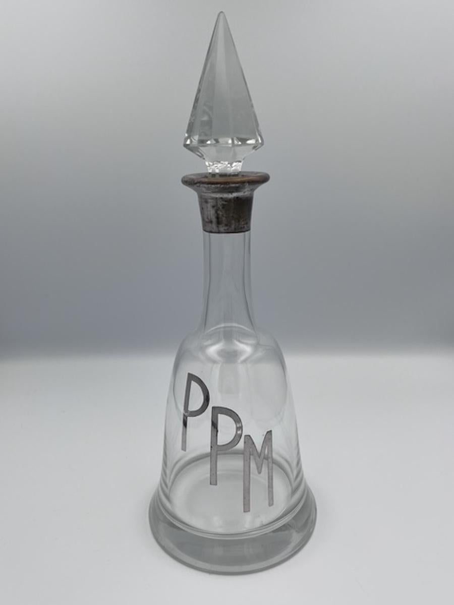 Questo elegante decanter in cristallo Art Deco degli anni '30 presenta una graziosa forma a campana ricurva e un monogramma in argento con la scritta 