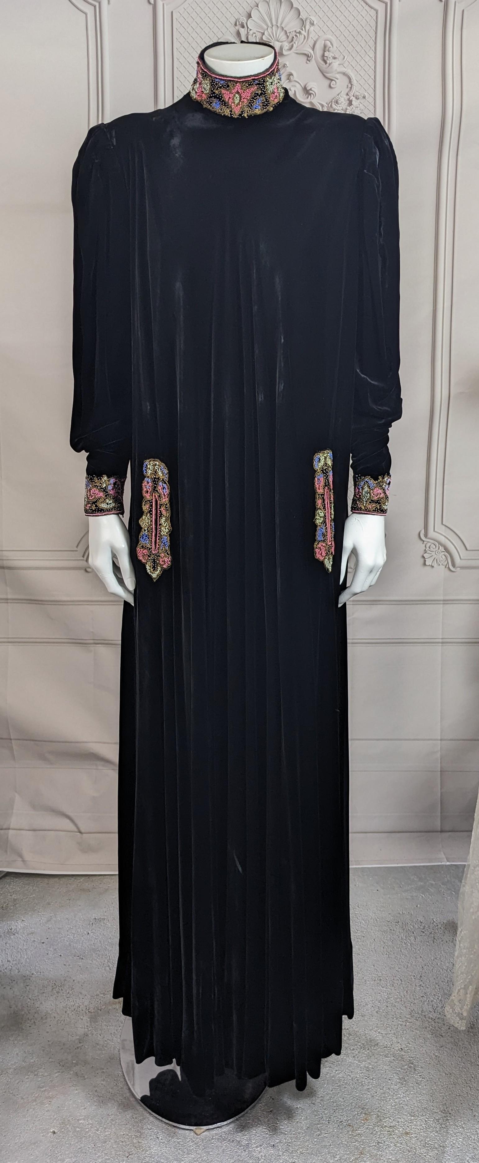 Austere and Elegant Art Deco Silk Velvet Beaded Gown from the 1930's, retailed by Saks Fifth Ave. NY. Elaborate hand beading at the neck, cuffs and pocket openings. Strong shouldered with tight zippered cuffs. The luxurious silk velvet is fully bias