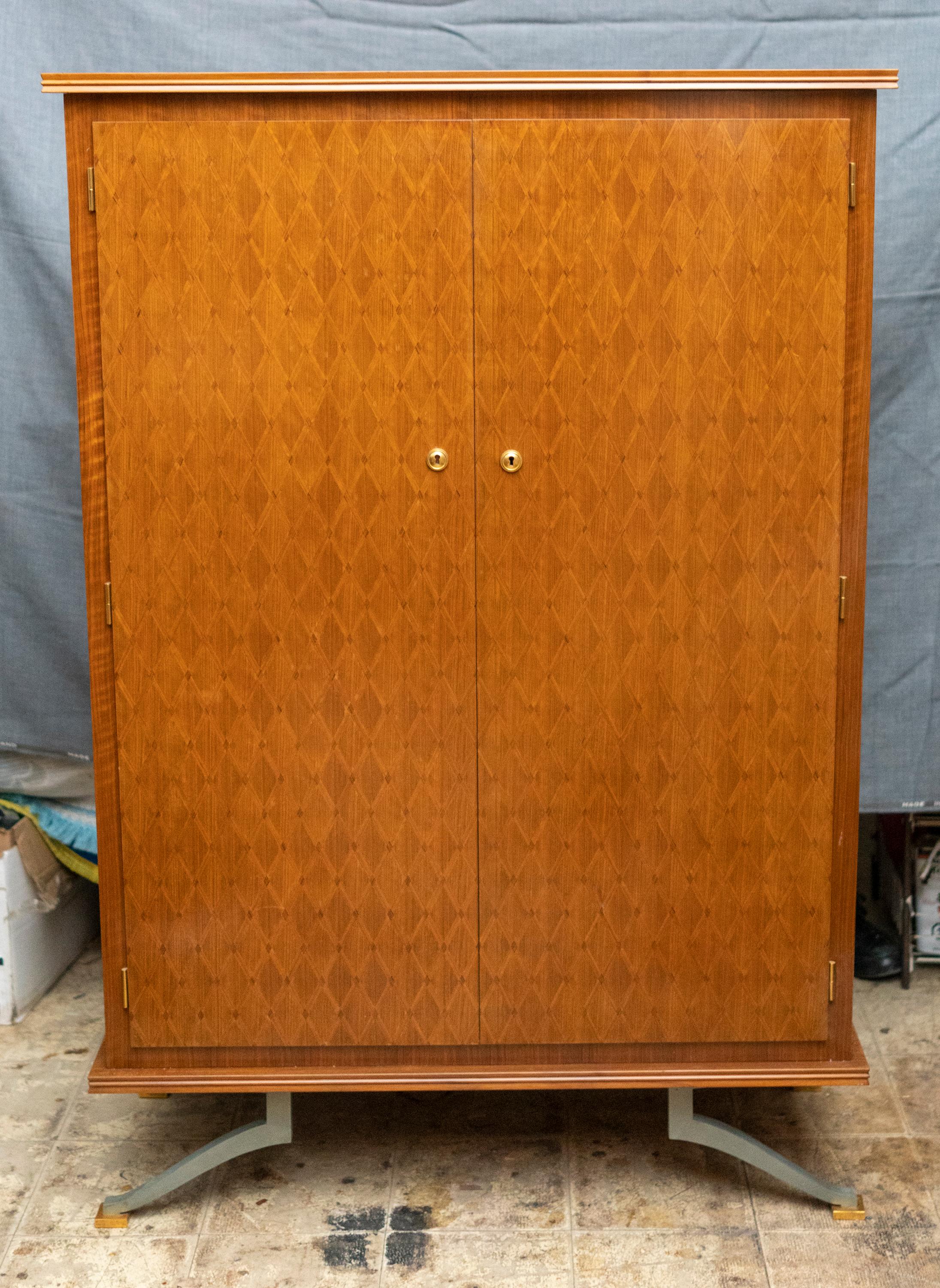 Elegant Art Deco period sycamore marquetry cabinet by Jules Leleu. Fitted with gilt bronze locks and
resting on patinated steel and gilt bronze feet. The interior includes a bar with sycamore shelves, mirrored floor for bottles or glass
