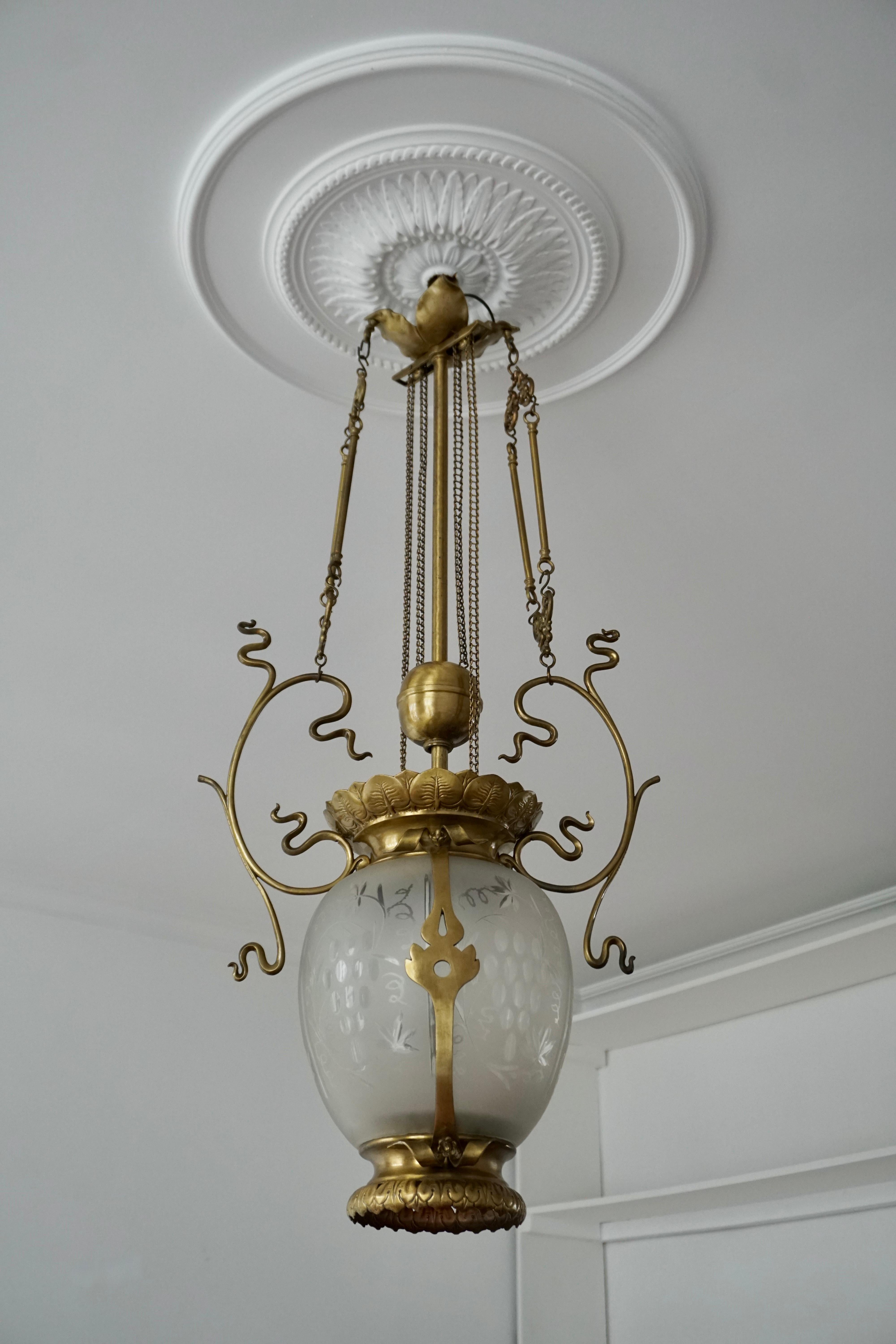 Eleganter Art-Deco-Kronleuchter oder -Laterne aus Messing und Glas.
Belgien, 1900-1930.

Die Leuchte benötigt eine einzelne E27-Schraubglühbirne (max. 100 Watt) und ist LED-kompatibel.

Maße: Höhe 95 cm.
Breite 44 cm.
Tiefe 23 cm.
