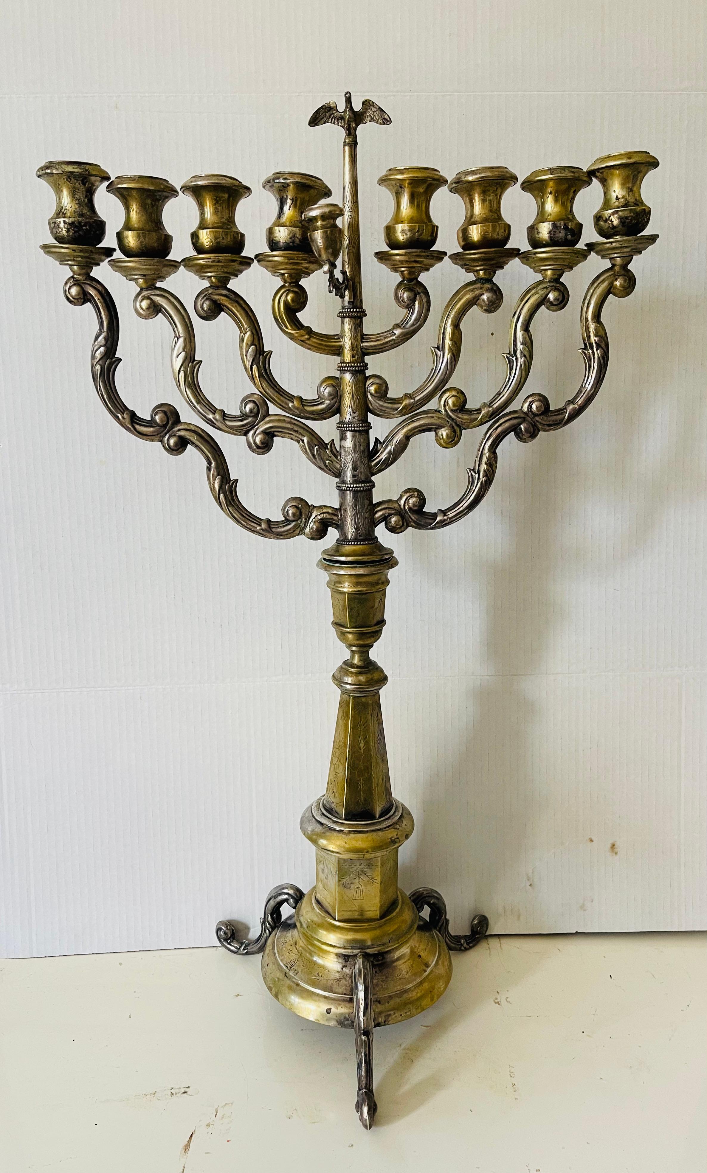 Rara e unica menorah austriaca in argento antico, incisa. Alta 27 pollici, su una base a treppiede. Composto da due parti con la figura dell'aquila sulla parte superiore. Ogni due bracci sullo stesso piano orizzontale possono essere smontati. Su