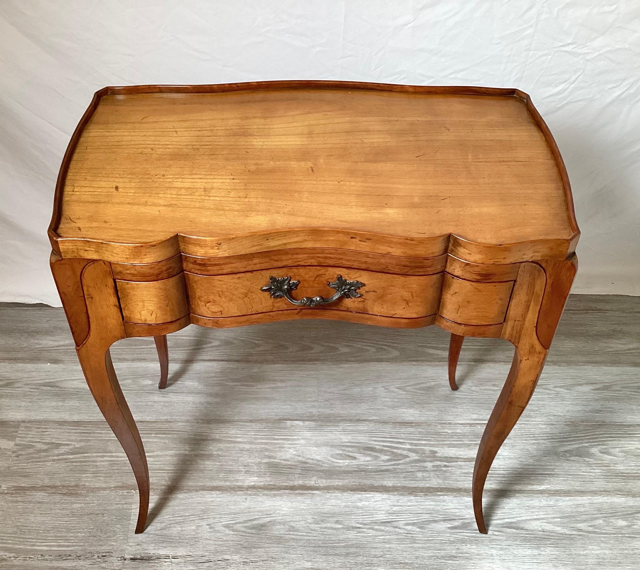 Elegant and beautifully made French style tray top table by Baker Furniture. The serpentine shape with a clever built in lift able tray top with front drawer. The table with four graceful cabriole legs. The tray when lifted is 7 inches tall.