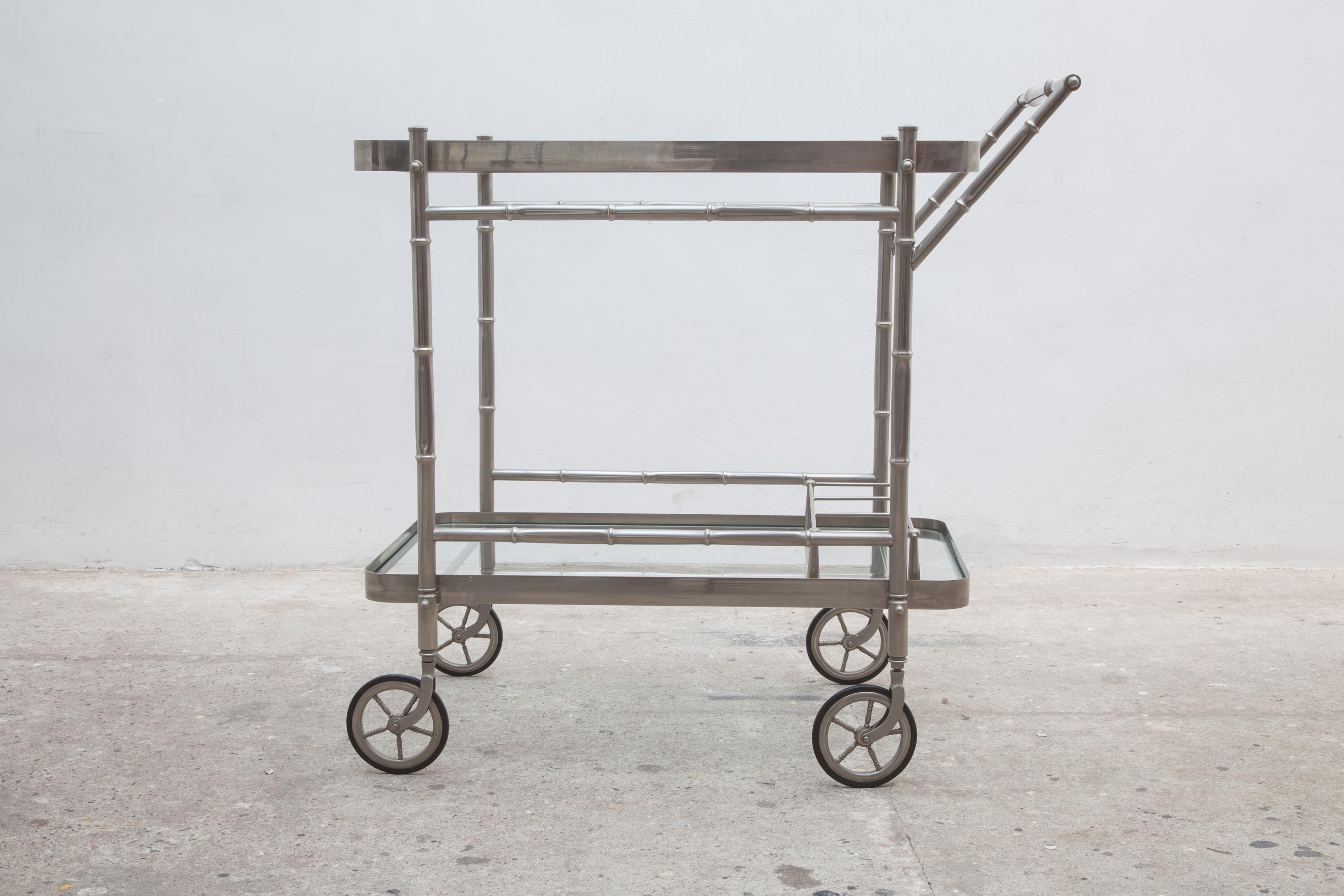Vintage French bar cart, trolley by Maison Baguès.Chrome, satin finish metal faux bamboo with clear glass shelves, removable tray,
and bottle holders on the bottom. Rubber wheels.Very sharp style and flawless details for this midcentury drinks