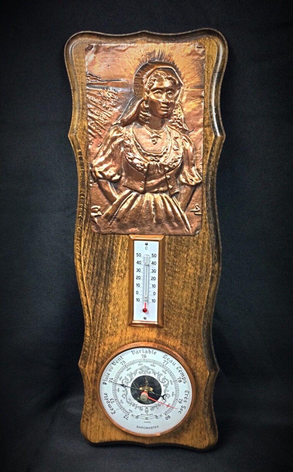 Enhance your décor with this stunning barometer and thermometer featuring a detailed copper bas-relief of a woman. Combining functionality with art, this piece is a beautiful example of 20th-century design.

Type: Barometer and