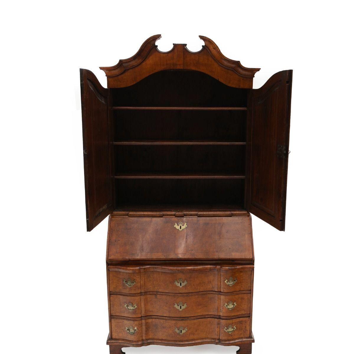 Beautiful baroque secretary desk with finely mirror-cut oak veneer and walnut root veneer.
The desk is in two parts: the lower section has three drawers with a straight break-front and a slanted writing flap, behind which are numerous small drawers