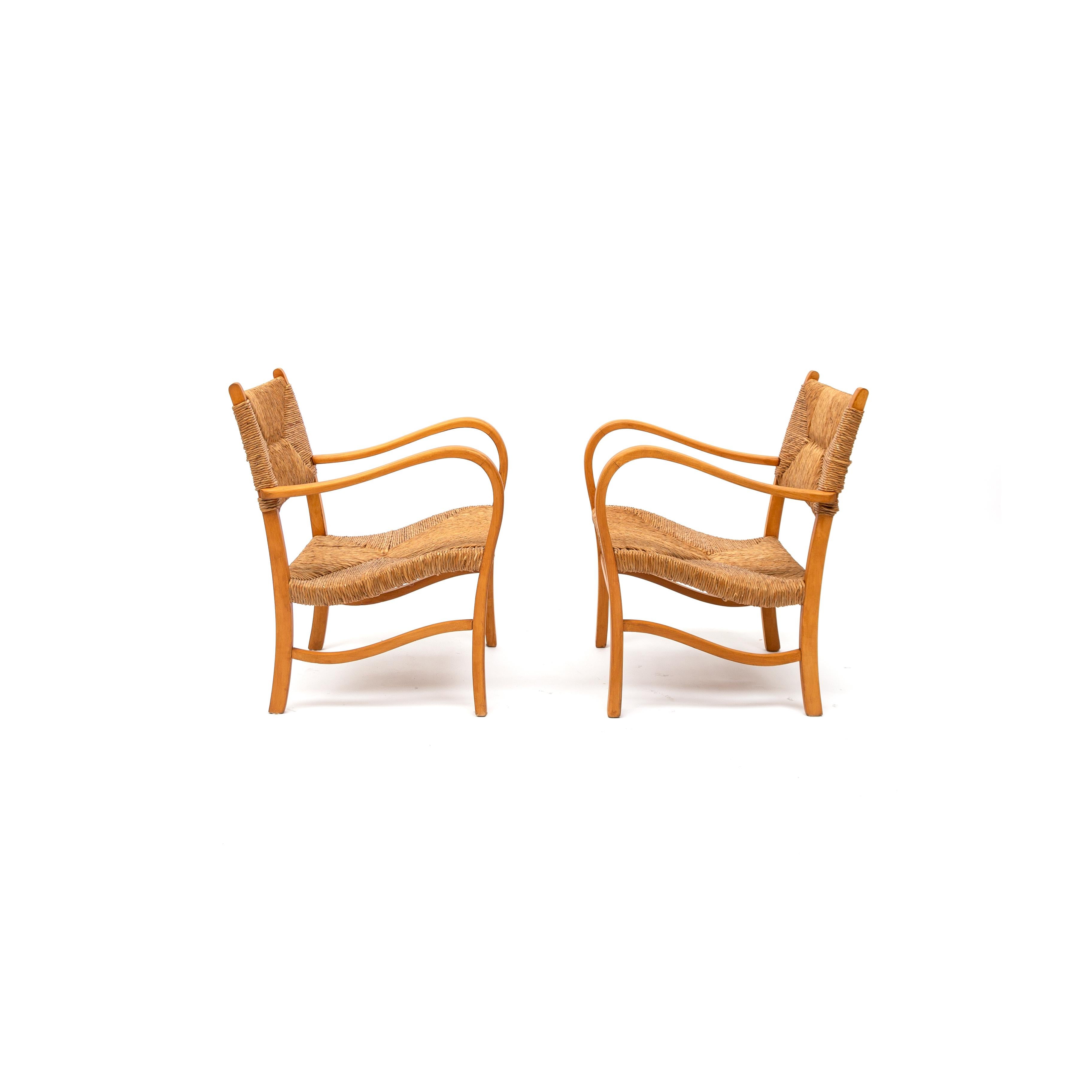 Queste poltrone ondulate ed eleganti sono realizzate con una struttura in legno di faggio curvato e sedute in giunco. Le dolci curve della struttura, riprese nei braccioli, conferiscono una qualità scultorea al set. Ispirati agli stili di Bas Van