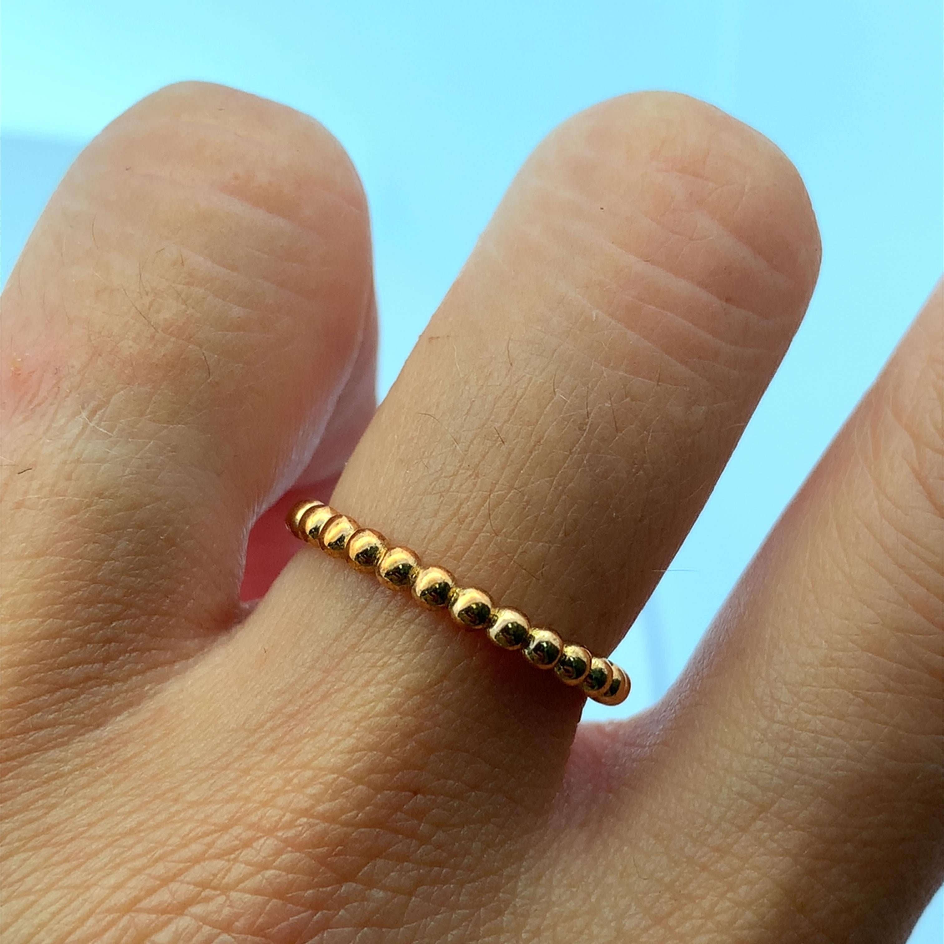 Dieser elegante, mit Perlen besetzte, stapelbare Ring ist aus glänzendem 18-karätigem Gelbgold gefertigt und besticht durch sein minimalistisches Design. Der Ring weist eine Reihe von glatten, kugelförmigen Mustern auf,  runde goldene Perlen, die