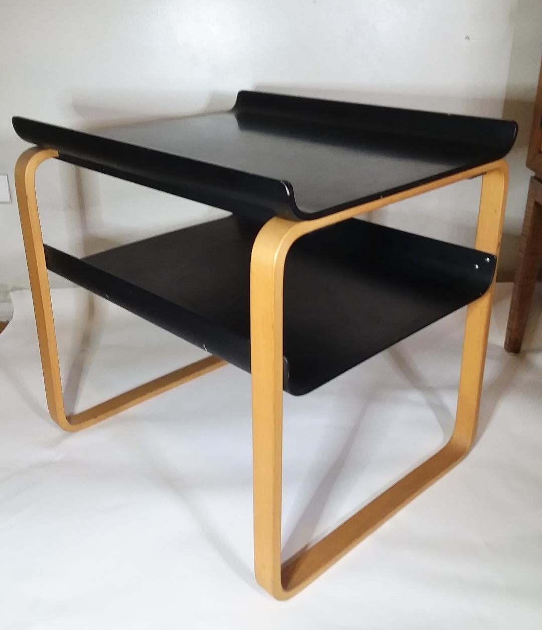 Elegant side table by Alvar Aalto, made from natural bent wood birch contrasting with black lacquer. Iconic design originally designed in 1932, originally for the Paimio Sanatorium in Finland. Table design 915.
Measures: 20.5
