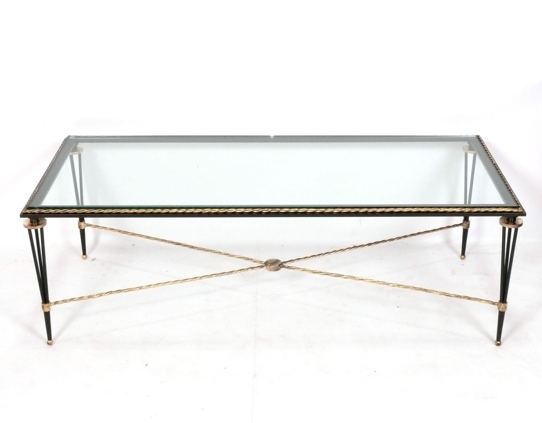 Elegante table basse en métal noir et doré, dans le style de Gilbert Poillerat, français, vers les années 1950.
