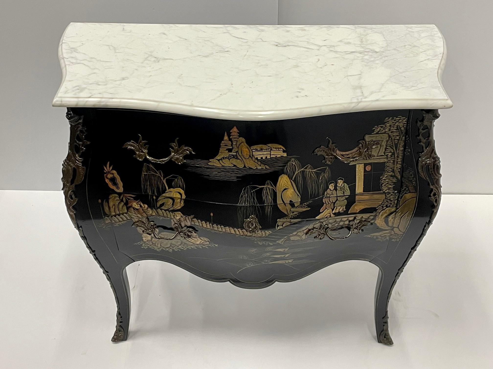 Superbly elegant Louis XV style bombay shaped French commode having black background and glamorous gold painted Chinoiserie scenes, cabriole legs, two drawers, and a contrasting white marble top. Bronze mounts.