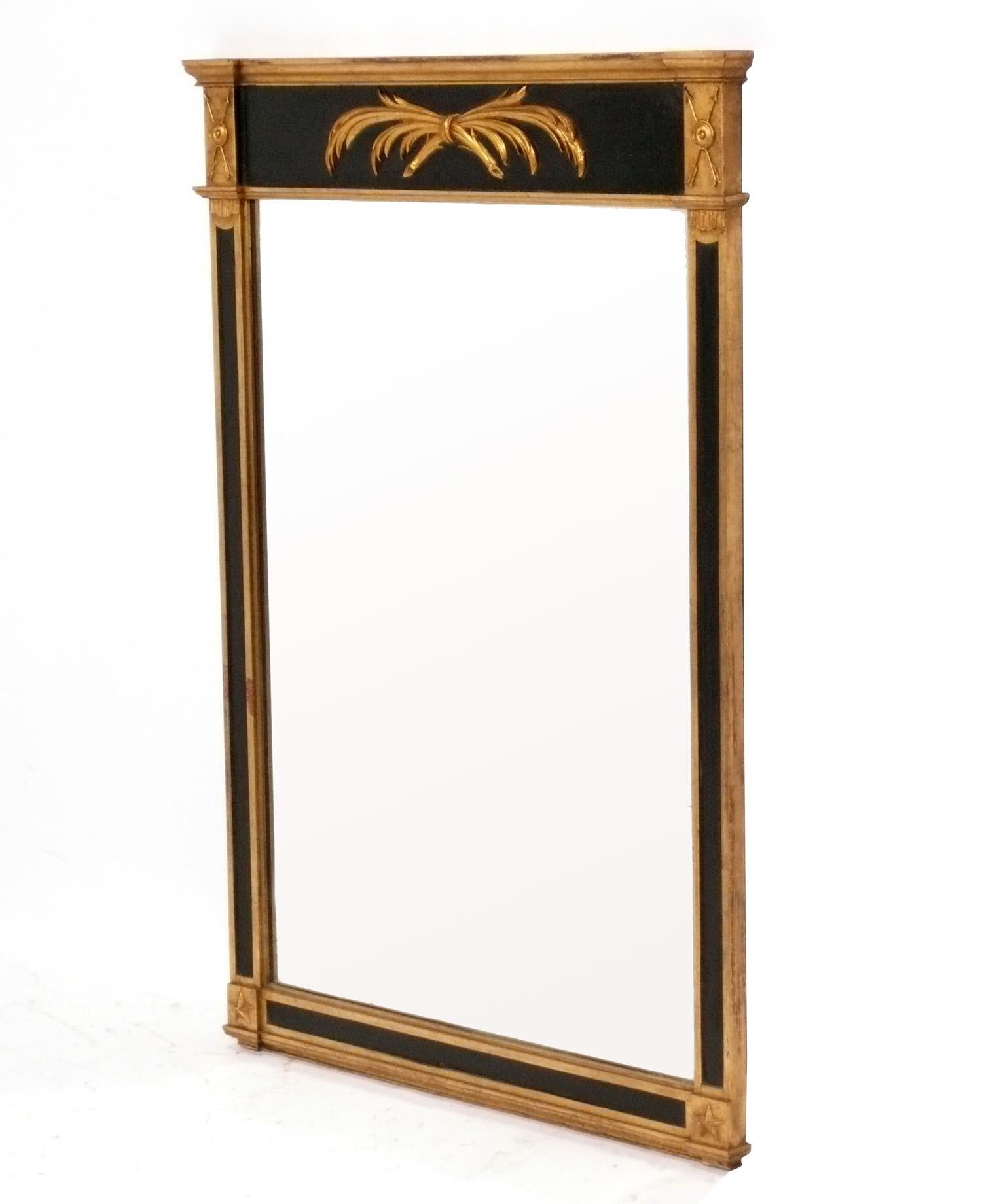 Elegante specchio nero e oro in stile Regency Revival o Neoclassico, americano, circa 1960. Conserva la calda patina originale.  