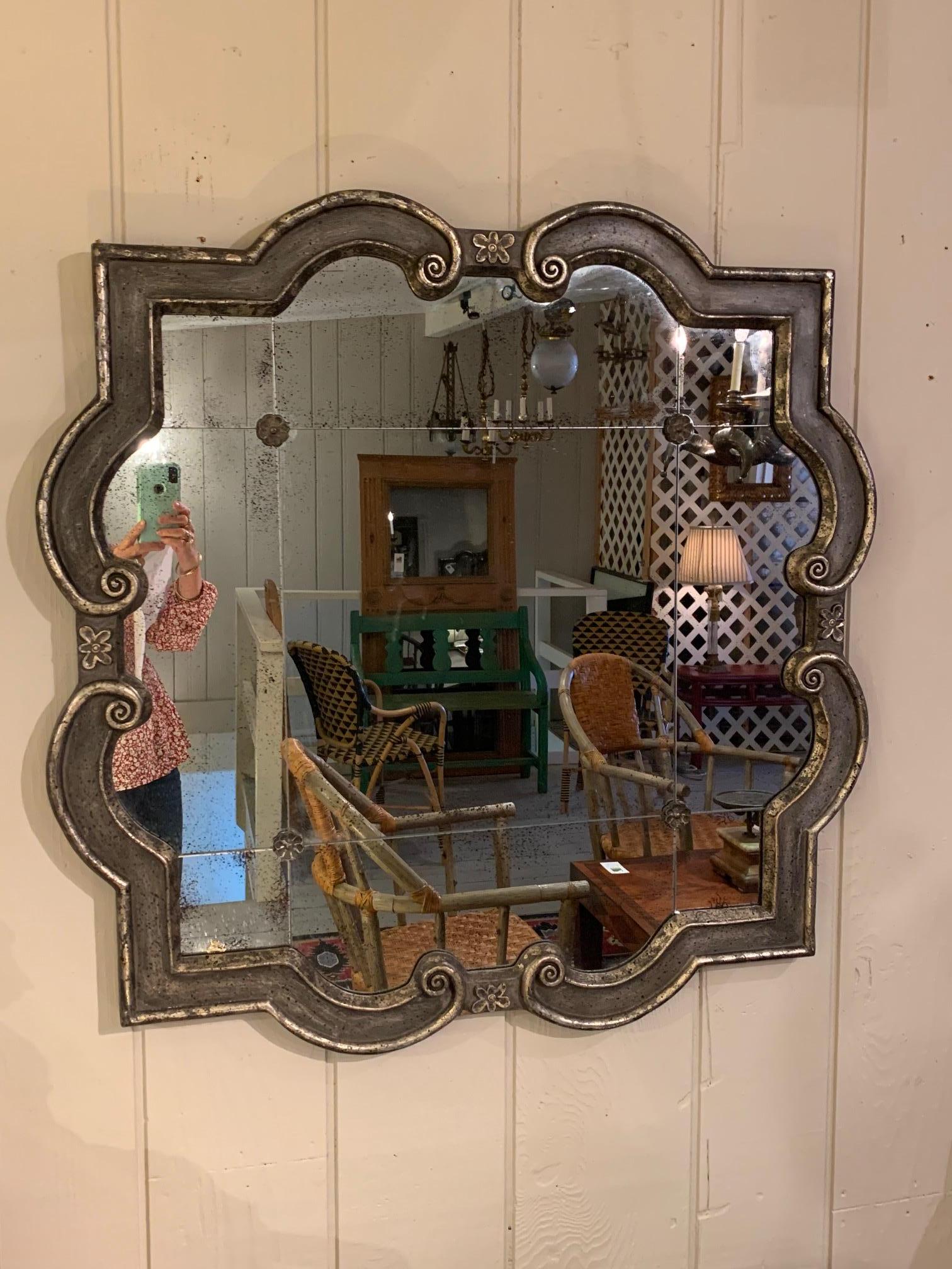 Wonderful almost square scalloped black and silvered mirror having aged mirror.  One available.