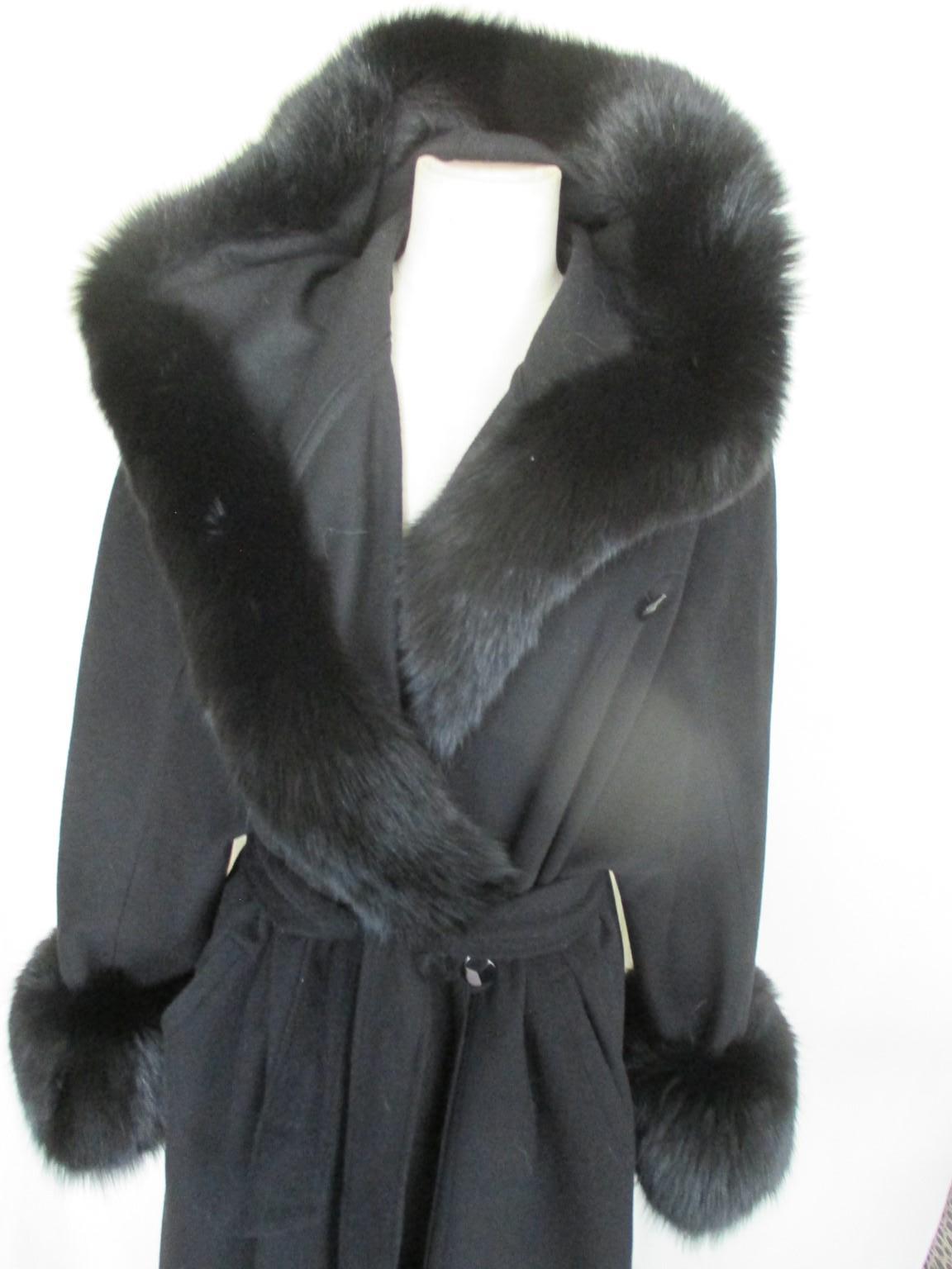 Flared Cashmere/wool coat with attached hood and soft black fox fur

 We offer more luxury fur and vintage items, view our frontstore.

Details:
Color: black
50% cashmere/ 50% lambs wool
Attached hood 
Trimmed with soft black fox fur
2 pockets
2