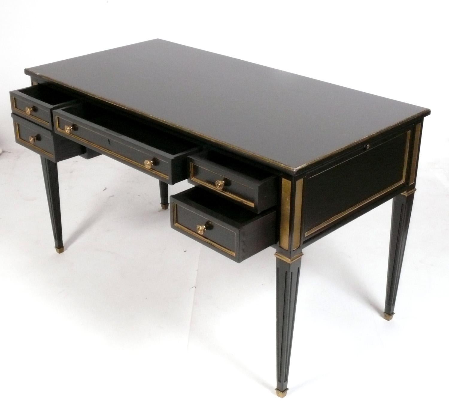 Elegantes, schwarz lackiertes Bureau Plat oder Schreibtisch im französischen Stil, vermutlich amerikanisch, um 1950. Er wurde kürzlich mit schwarzem Lack überarbeitet. Die Messingbeschläge und -säbel haben ihre warme Originalpatina behalten.
