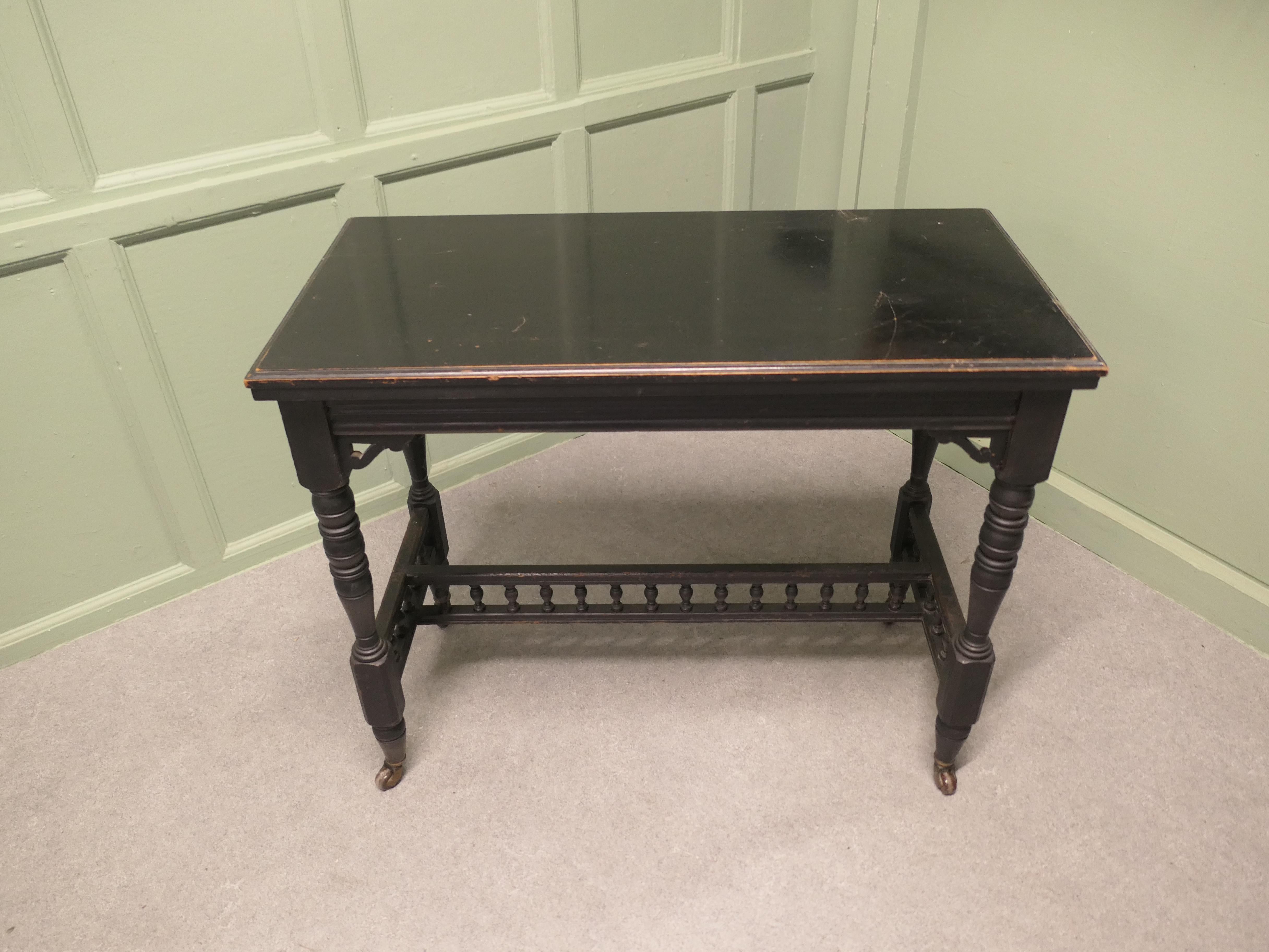 Elegant Black Lacquer Games, Card or Hall Table

 This stylish Victorian piece has an ebonised finish which is a smooth slightly shiny black finish 
The top of the table twists round and opens out to reveal a red base playing area and a small