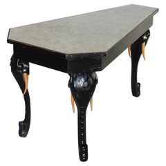 lgante table  pattes d'lphant en laque noire et en verre  feuilles d'argent