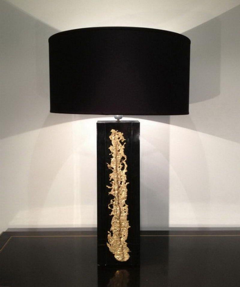 This very nice an elegant table lamp is made of black lacquered resina with a decorative bronze Decoration. This is a French work. Circa 1970