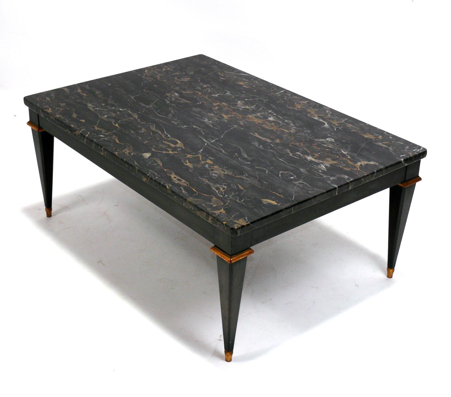 Elegant Black Marble Regency Style Coffee Table, by Baker Furniture, circa 1970s. Constructed of a beautiful piece of black marble with gold veining over a black lacquered and parcel gilt wood base. 