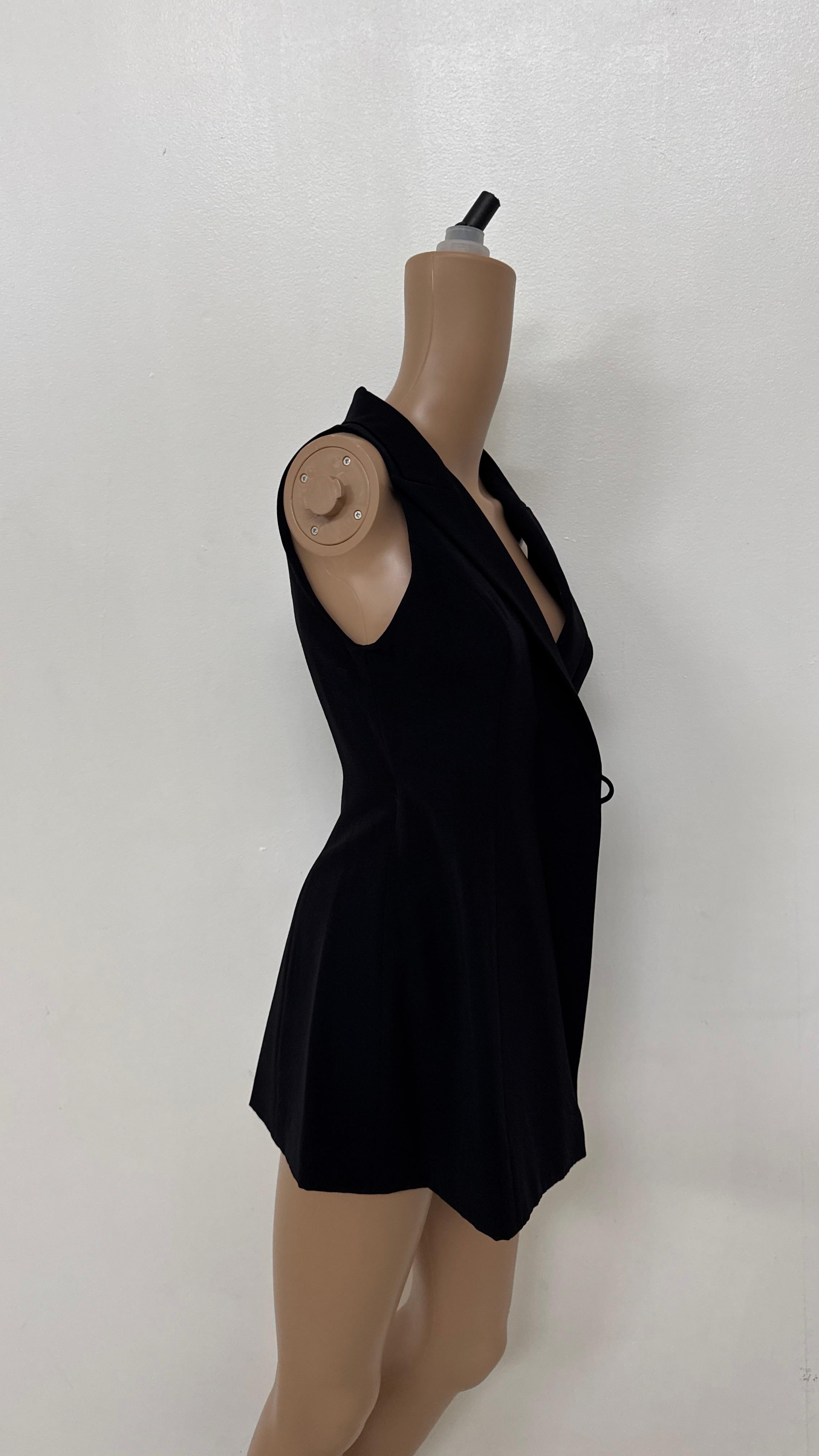 Discover refined minimalism with this black long wrap vest by Plein Sud. Designed with a strong tailored silhouette, it features a deep V-neckline, sharp notched lapels, and a sleek, sleeveless cut. The front wrap closure is adjustable, allowing for