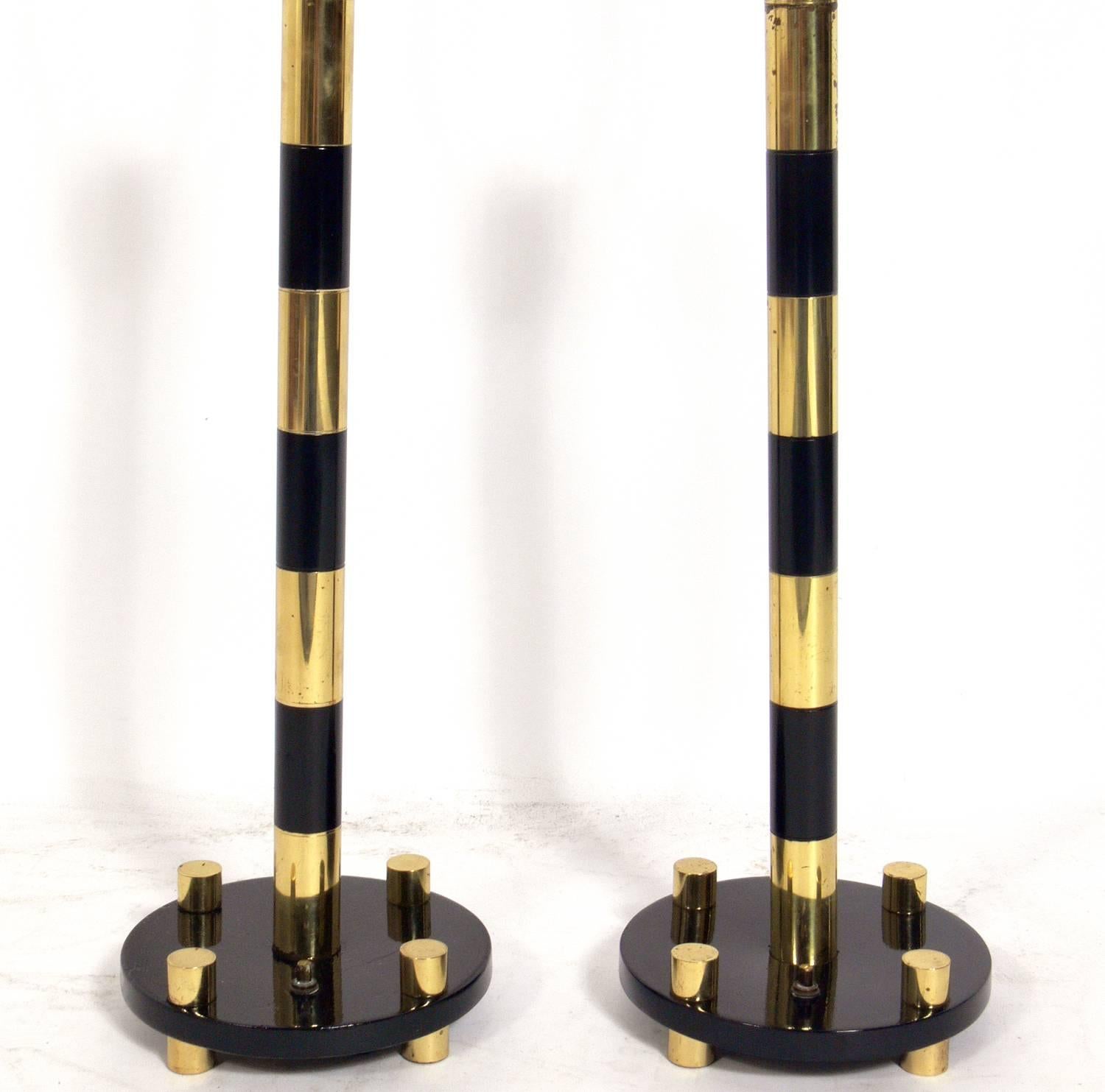 Elegant brass and black lamps, in the manner of Tommi Parzinger, American, circa 1950s. They have been rewired and are ready to use. The price noted below includes the shades.