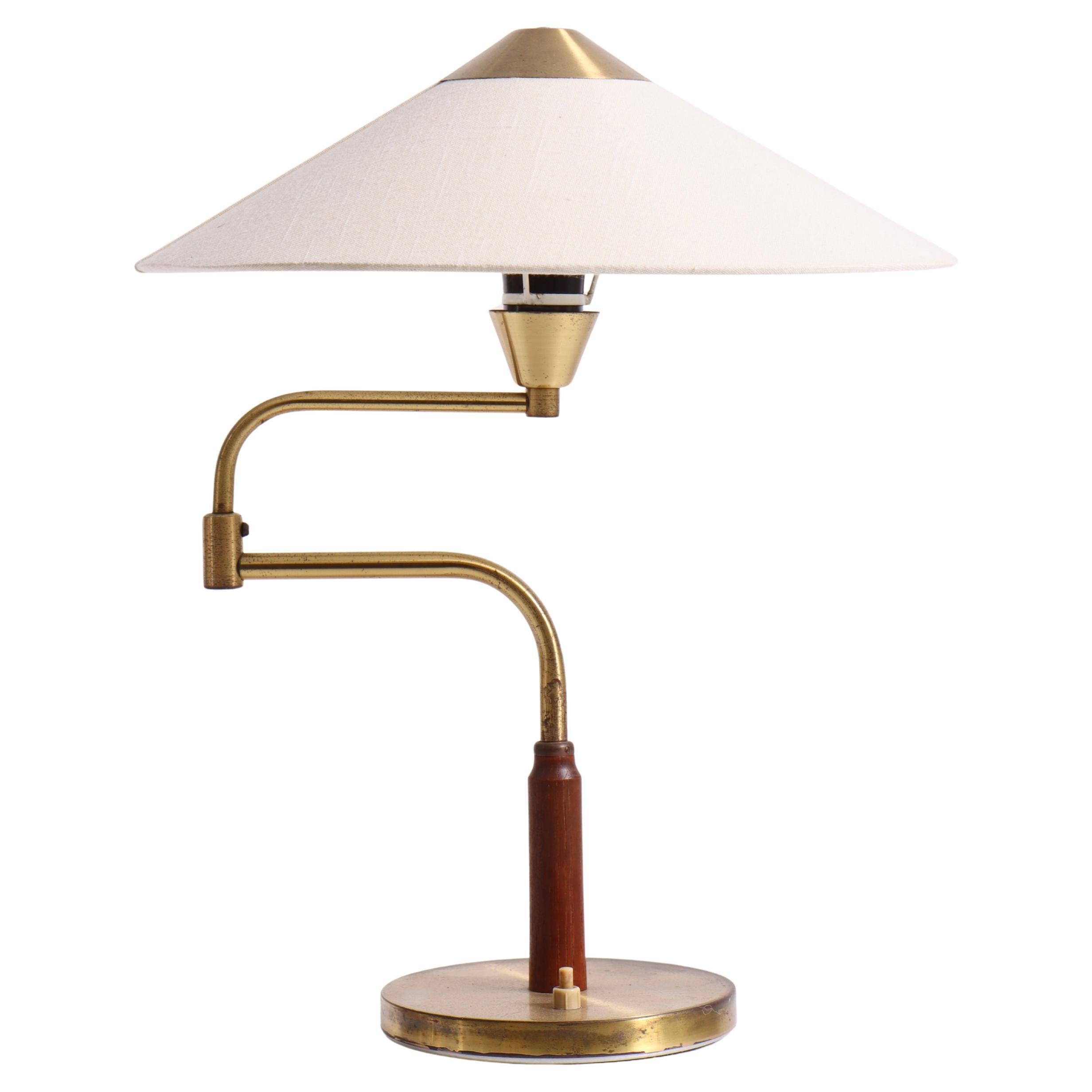 Elegante lámpara de mesa de latón y teca de Bent Karlby con brazo ajustable y tela en venta
