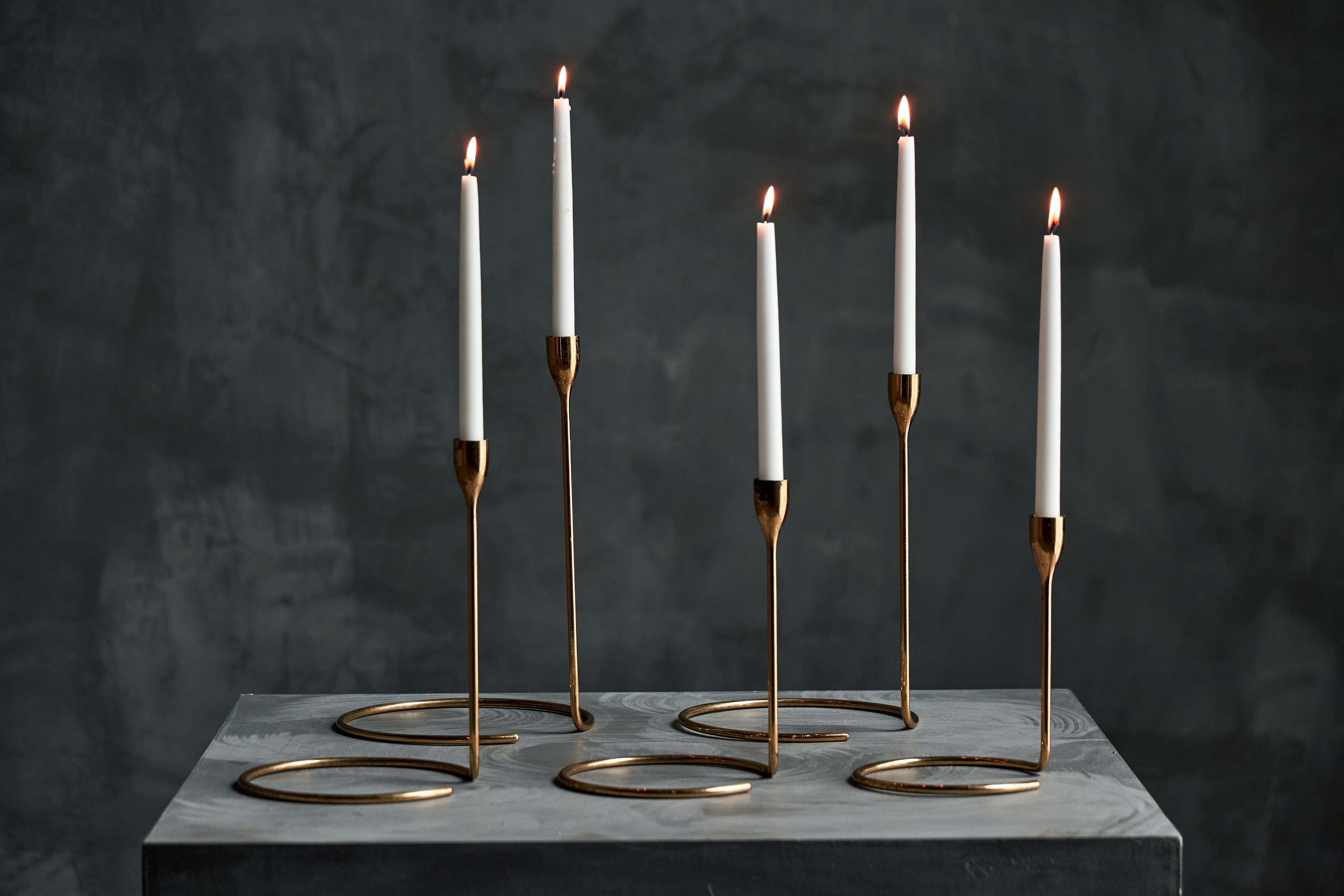 Questo esclusivo set di portacandele in ottone proveniente dalla Danimarca è una miscela magistrale di design minimalista ed eleganza scandinava. Caratterizzati da steli sottili e allungati che accolgono candele di tipo taper. Il design della base