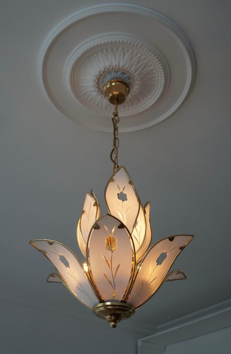 Elegant brass chandelier with white Murano glass leaves. 

Measures: 
Diameter 45 cm. 
Height fixture 43 cm. 
Total height including the chain and canopy 85 cm. 
The light requires six single E14 screw fit lightbulbs (60Watt max.) LED